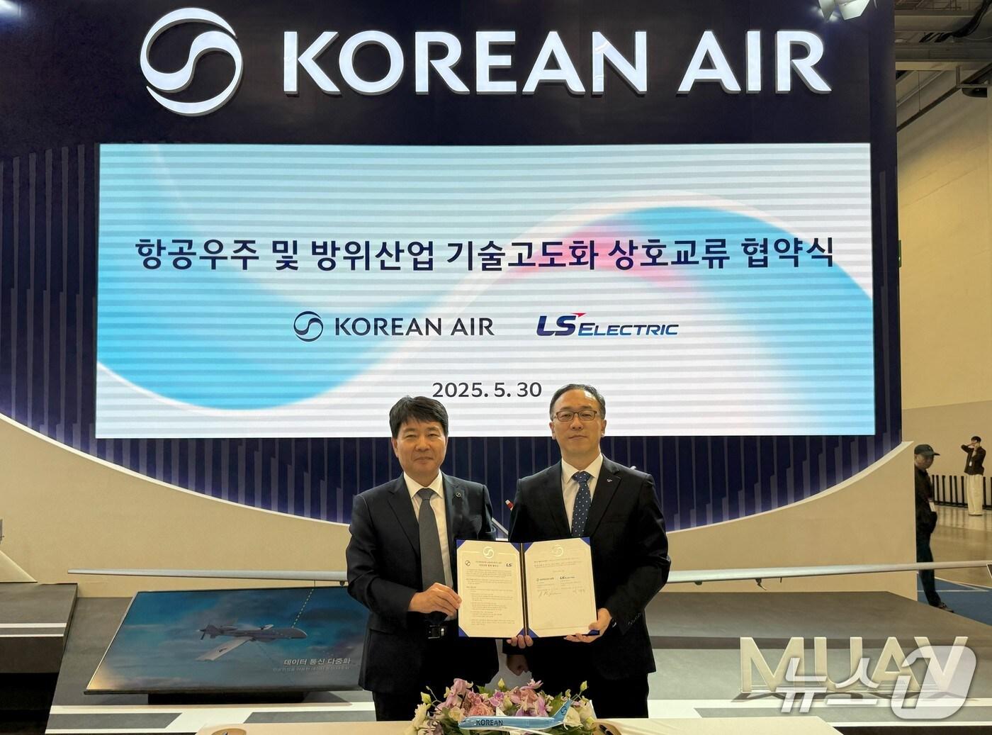 본문 이미지 -  대한항공과 LS일렉트릭은 30일 부산 벡스코에서 열리고 있는 국제해양방위산업전(MADEX)에서 항공우주 및 방위산업 기술 고도화를 위한 협약을 체결했다. 대한항공 임진규 항공우주사업본부장(왼쪽)과 이상준 LS일렉트릭 자동화CIC최고운영책임자가 기념 촬영하고 있는 모습.(대한항공 제공)