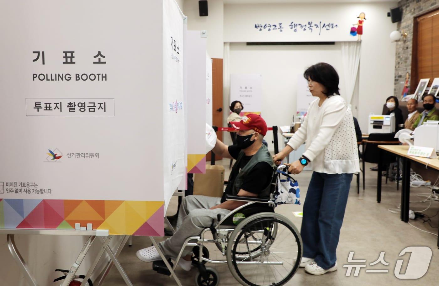 제21대 대통령 선거 사전투표 이틀차인 30일 오전 울산 중구 병영2동 사전투표소에서 한 휠체어를 탄 한 유권자가 보조인의 도움을 받아 기표소로 들어가고 있다. 2025.5.30/뉴스1 ⓒ News1 김세은 기자