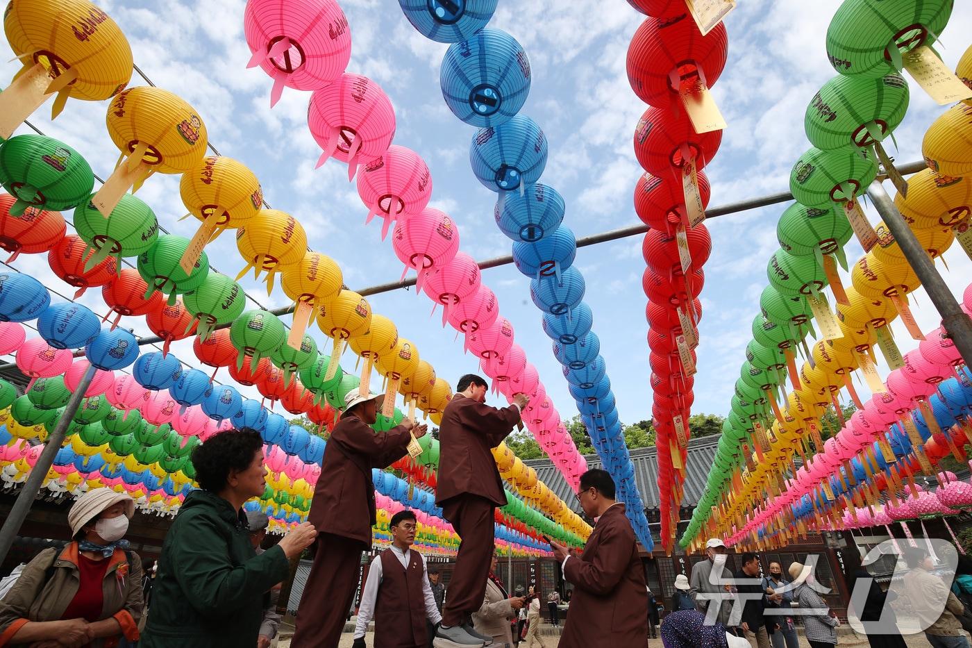 본문 이미지 - 불기 2569년 부처님 오신 날이던 지난 5일 오전 대구 동구 동화사를 찾은 불자들이 대웅전 앞 봉축 연등에 소원지를 매달고 있다. 2025.5.5/뉴스1 ⓒ News1 공정식 기자