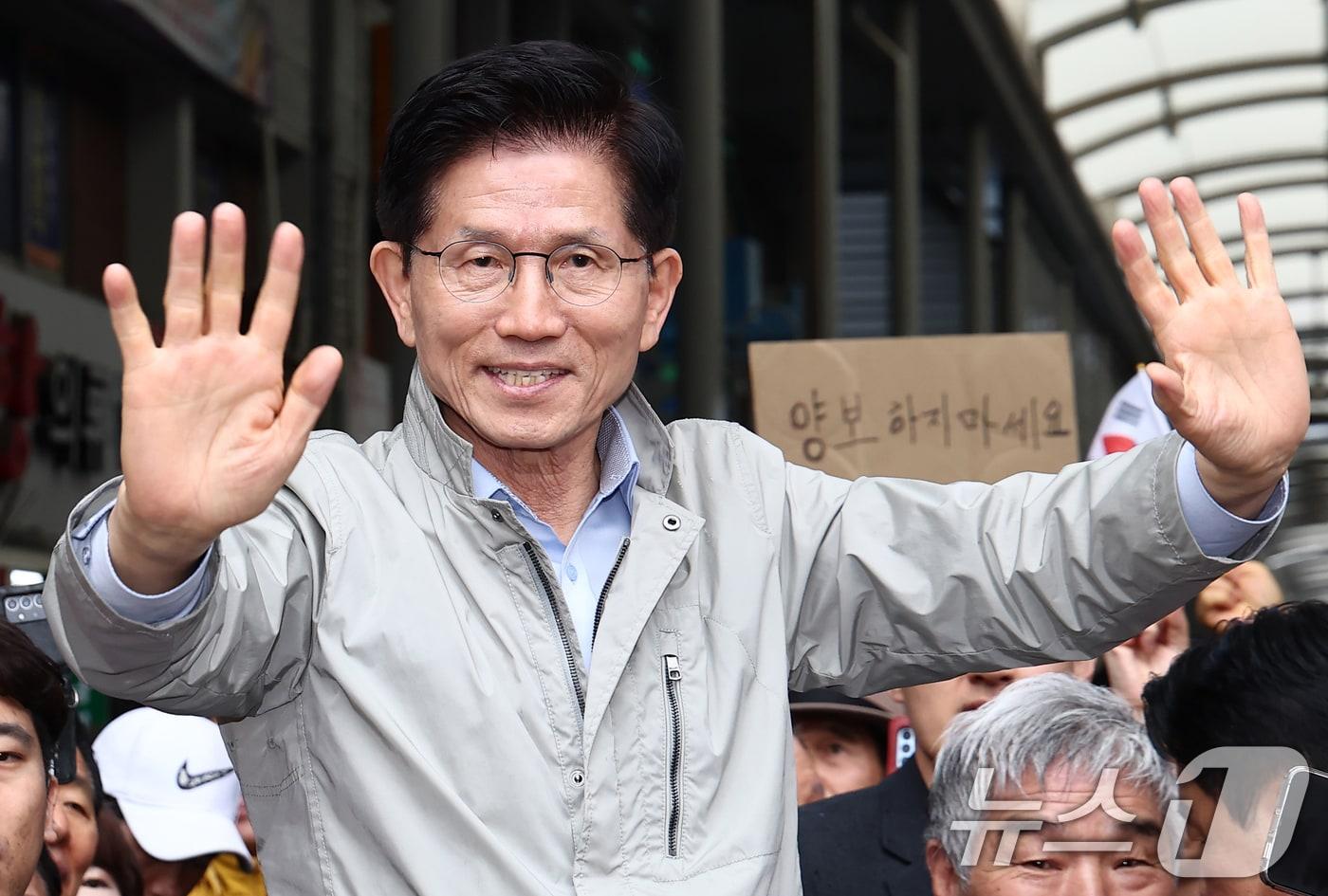 김문수 국민의힘 대통령 후보가 6일 경북 포항시 죽도시장에서 시민들을 향해 인사하고 있다. 뒷편에는 한 지지자가 '양보 하지 마세요'라고 적힌 종이를 들어보이고 있다. 2025.5.6/뉴스1 ⓒ News1 김민지 기자