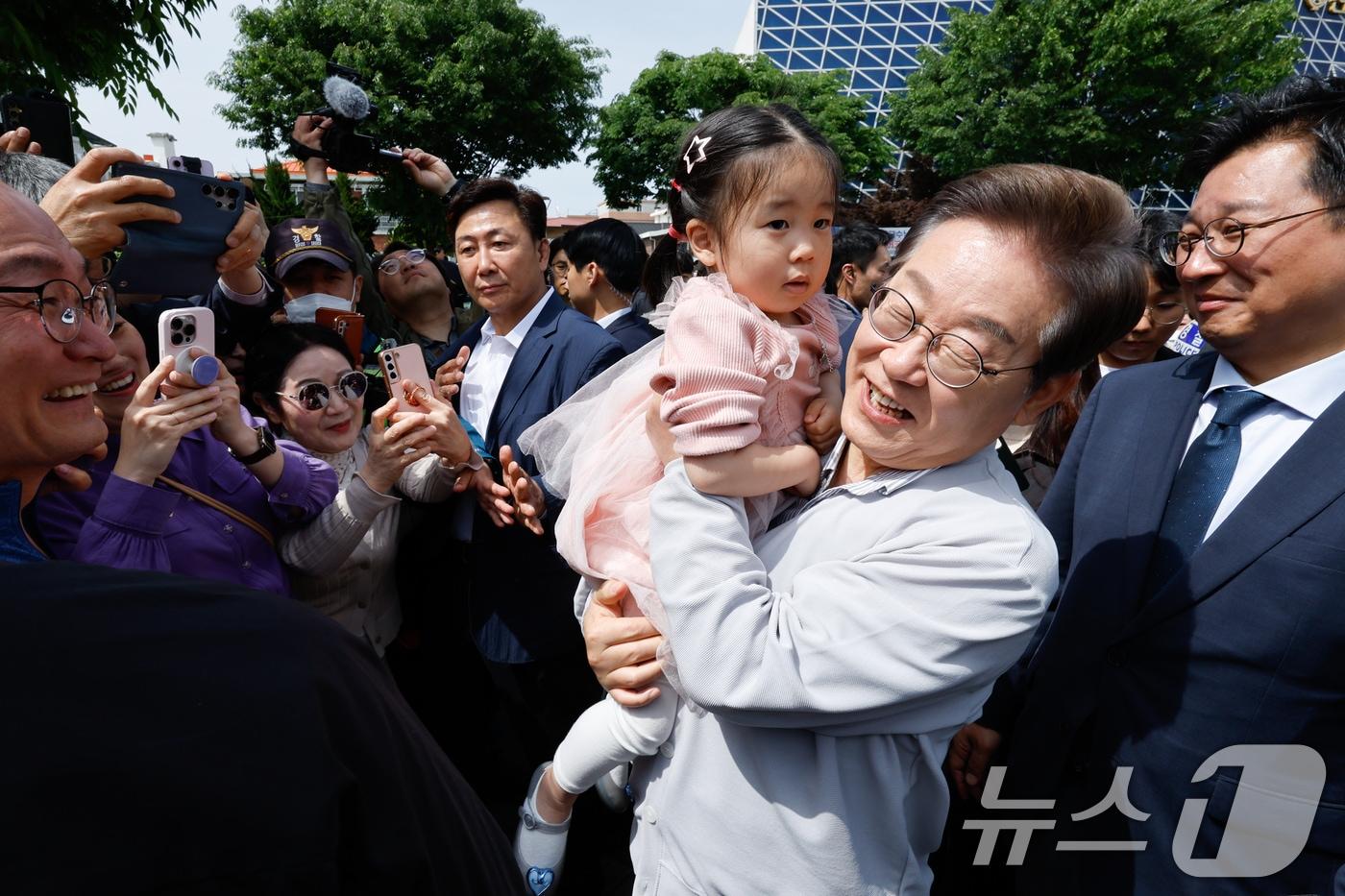 본문 이미지 - 이재명 대통령이 지난해 5월 대선 후보 시절 전북 전주시 풍남문 앞에서 한 어린이를 안고 있다. 2025.5.7 ⓒ 뉴스1 안은나 기자