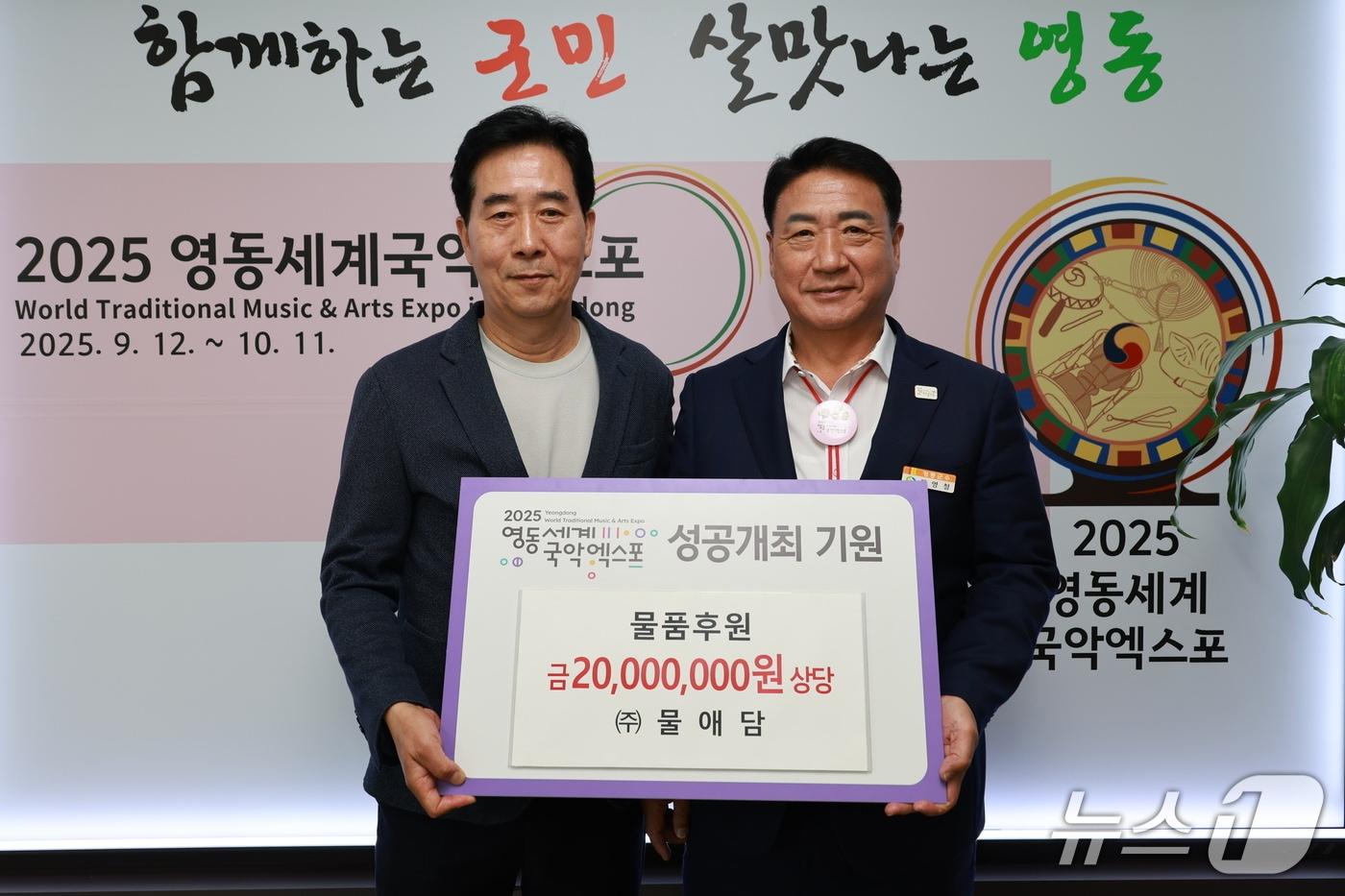 본문 이미지 - 7일 정용래 물애담 대표(왼쪽)가  영동세계국악엑스포 성공 개최를 기원하며 물품을 기탁하고 있다. (영동군 제공. 재판매 및 DB금지) /뉴스1