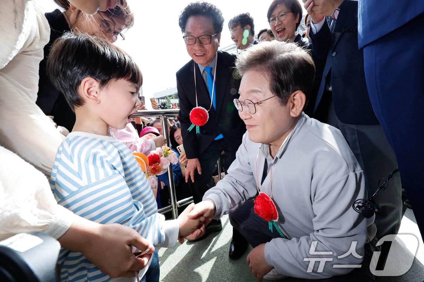 이재명 더불어민주당 대통령 후보가 2차 골목골목 경청투어 마지막 날인 7일 오후 전북 익산시 대한노인회 익산지회에서 열린 임원과의 간담회에 참석하기 전 어린이로부터 카네이션 콕걸이를 선물받고 있다. 2025.5.7/뉴스1 ⓒ News1 안은나 기자