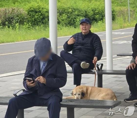 본문 이미지 - 윤석열 전 대통령이 지난 5일 반려견, 경호원 3명과 함께 동작대교 부근 한강을 산책하다 잠시 쉬고 있는 모습이 누리꾼에 의해 포착됐다. &#40;&#40;온라인 커뮤니티 &#39;클리앙&#39; 갈무리&#41;ⓒ 뉴스1