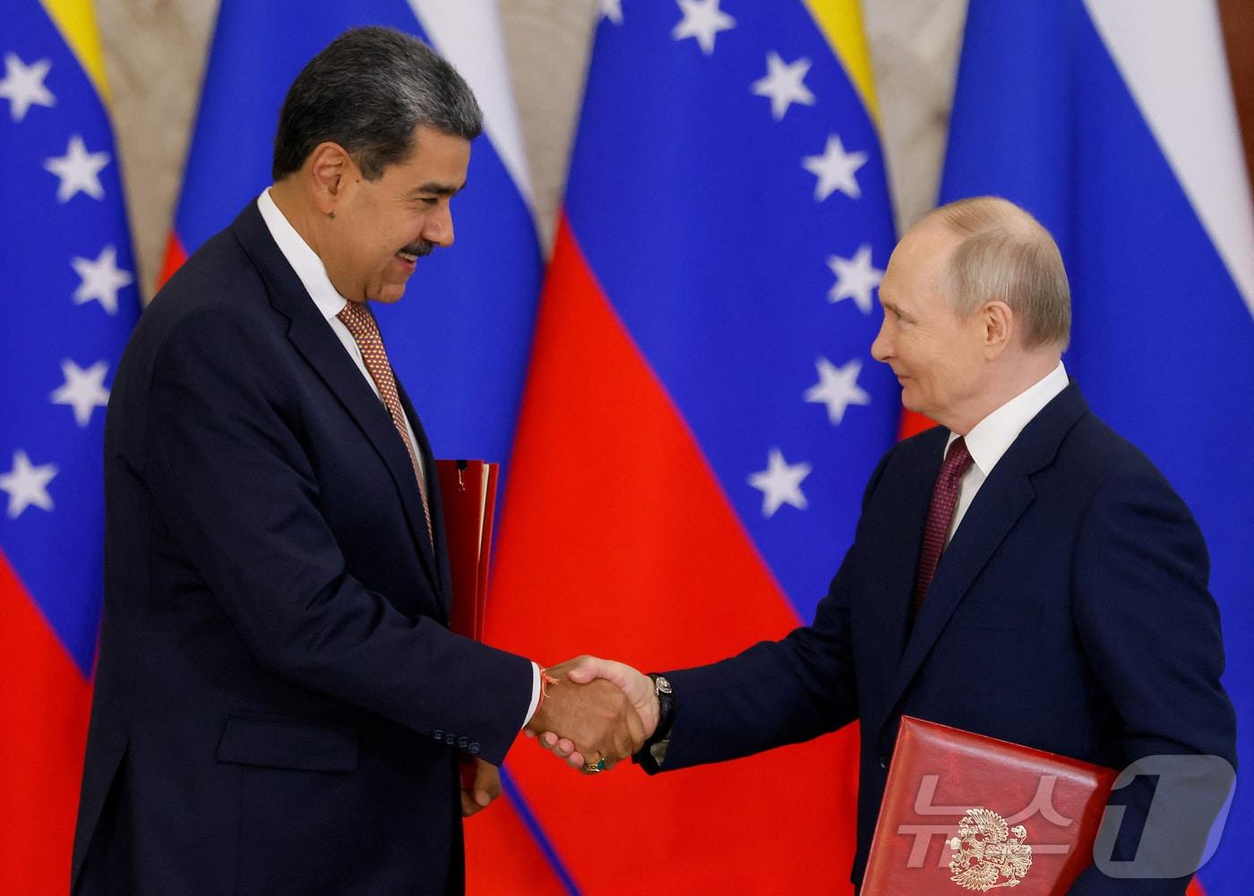 본문 이미지 - 7일&#40;현지시간&#41; 블라디미르 푸틴 러시아 대통령&#40;오른쪽&#41;과 니콜라스 마두로 베네수엘라 대통령이 모스크바 크렘린궁에서 양국간 전략적 파트너십 협정에 서명한 뒤 악수하고 있다. 2025.05.07 ⓒ 로이터=뉴스1 ⓒ News1 김지완 기자
