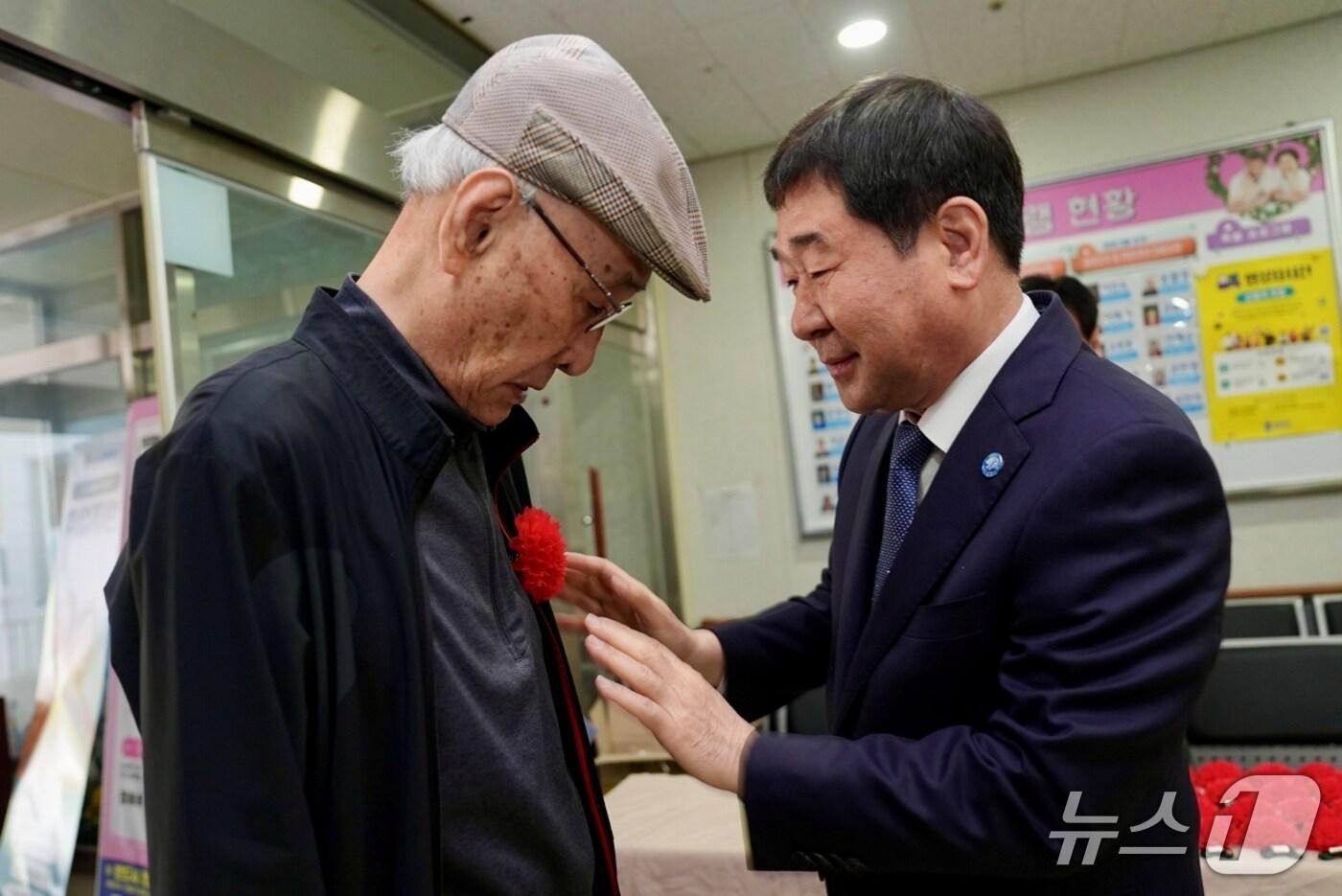 이재영 충북 증평군수가 8일 증평군노인복지관을 찾아 어르신에게 카네이션을 달아드리고 있다.(증평군 제공)/뉴스1