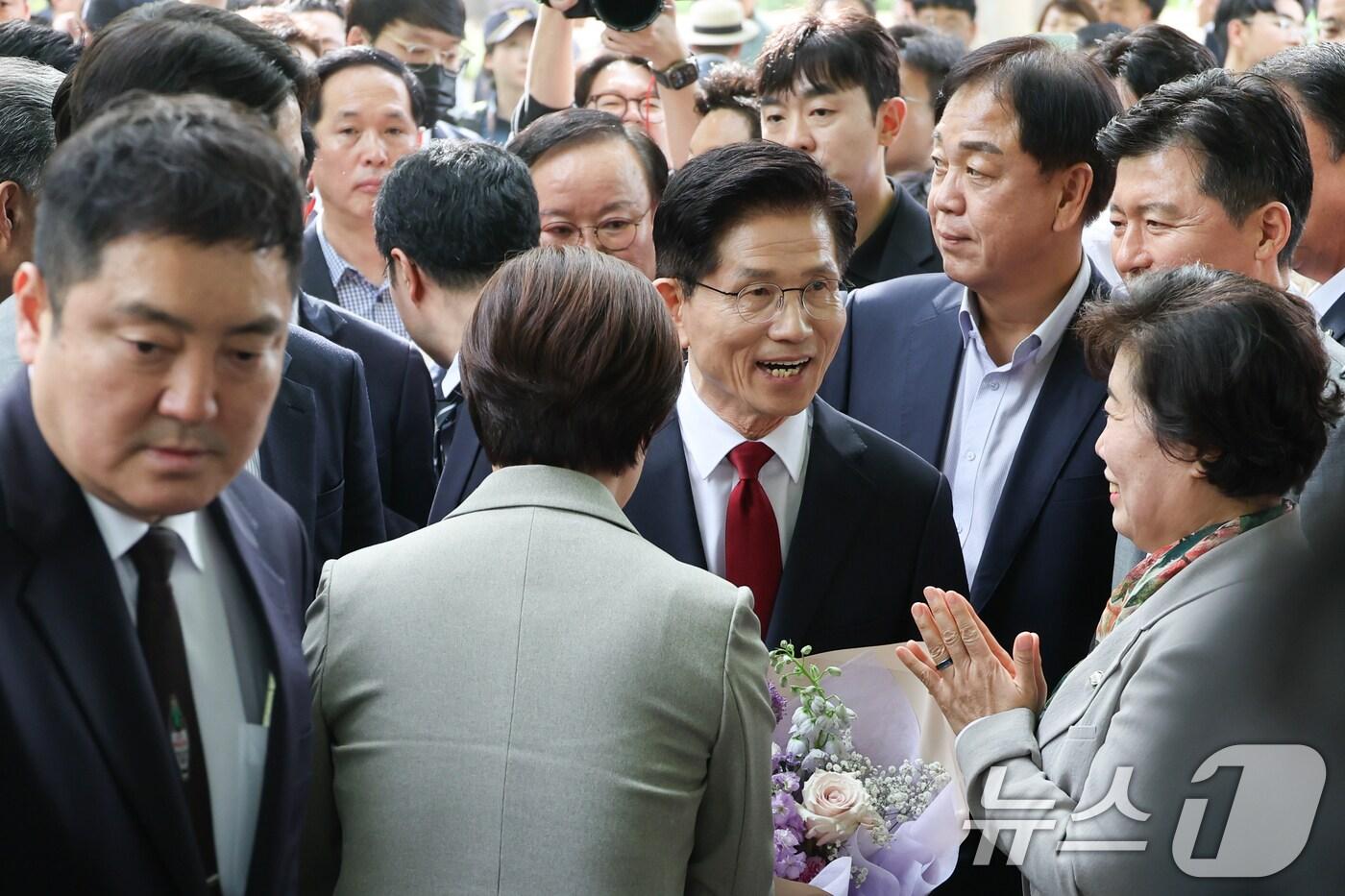 본문 이미지 - 김문수 국민의힘 대통령 후보가 8일 오후 서울 여의도 국회 강변서재에서 한덕수 무소속 대선 예비후보와 후보 단일화 관련 공개 회동을 하기 위해 입장하며 꽃다발을 받고 있다. 2025.5.8/뉴스1 ⓒ News1 안은나 기자