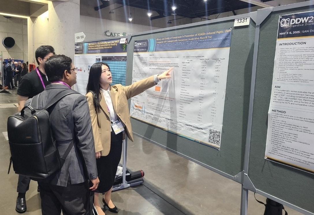 본문 이미지 -  해외 의료진(왼쪽)이 펙수클루(펙수프라잔)의 NSAIDs 유도 소화성궤양 예방 임상연구 결과를 보고 있다. (대웅제약 제공)