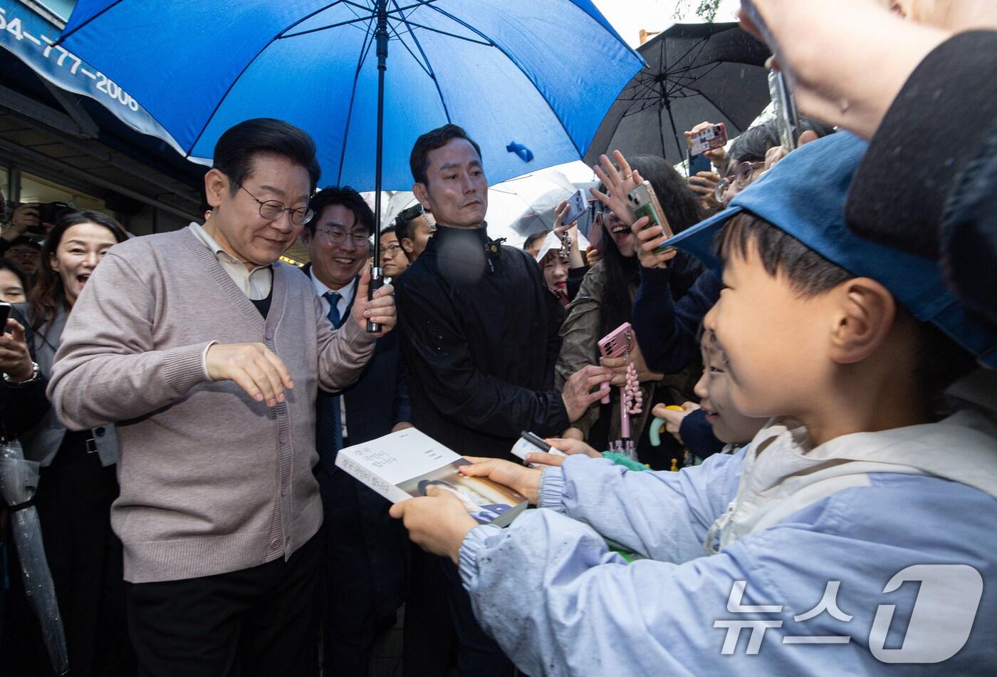 3차 경청투어에 나선 이재명 더불어민주당 대통령 후보가 9일 오전 경북 경주시 한 아파트 단지를 찾아 어린이들의 사인 요청을 받고 있다. 2025.5.9/뉴스1 ⓒ News1 이재명 기자