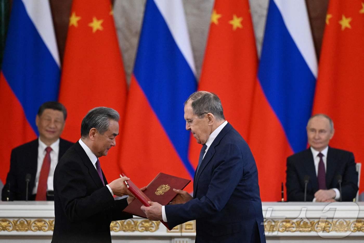 본문 이미지 - 블라디미르 푸틴 러시아 대통령과 시진핑 중국 국가주석이 8일(현지시간) 모스크바 크렘린 궁에서 세르게이 라브로프 러시아 외무장관과 왕이 중국 외교부장의 협약서 교환을 지켜 보고 있다. 2025.05.09 ⓒ AFP=뉴스1