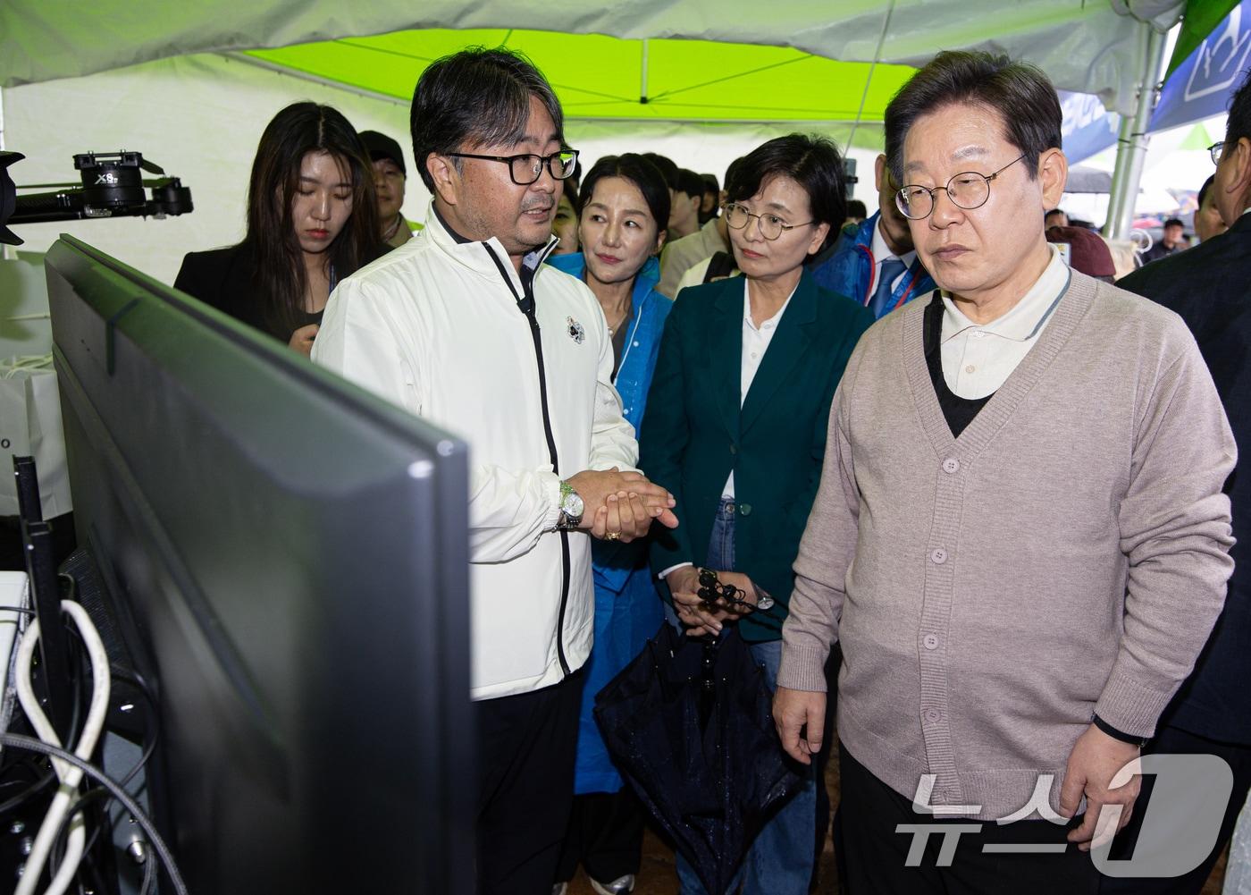본문 이미지 - 3차 경청투어에 나선 이재명 더불어민주당 대통령 후보가 9일 오후 경북 김천시 김천실내체육관 일대에서 열린 제63회 경북도민체육대회에 마련된 4차산업 체험관을 찾아 관계자에게 드론 관련 설명을 듣고 있다. 2025.5.9/뉴스1 ⓒ News1 이재명 기자