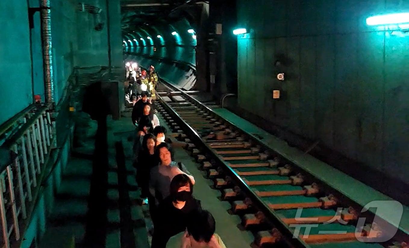 본문 이미지 - 31일 오전 서울 지하철 5호선 마포역~여의나루역 구간을 지나는 열차에서 방화로 인한 화재가 발생, 승객들이 선로를 통해 대피하고 있다. (영등포소방서 제공. 재판매 및 DB 금지) 2025.6.1/뉴스1