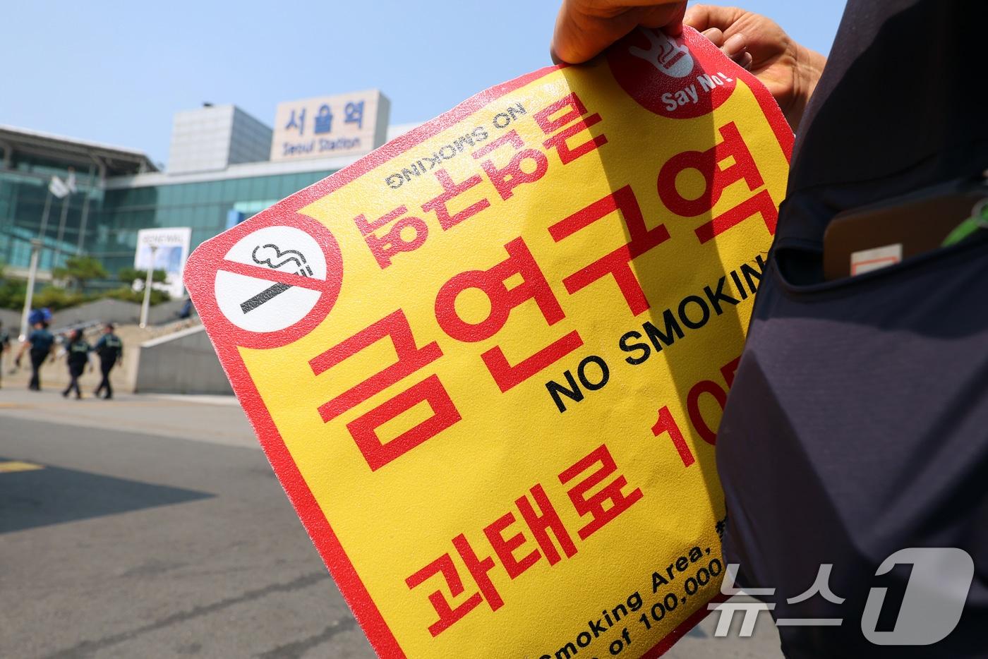 본문 이미지 - 서울역광장에서 중구청 관계자들이 '금연구역' 안내 스티커를 붙이고 있다 2025.6.1/뉴스1 ⓒ News1 황기선 기자