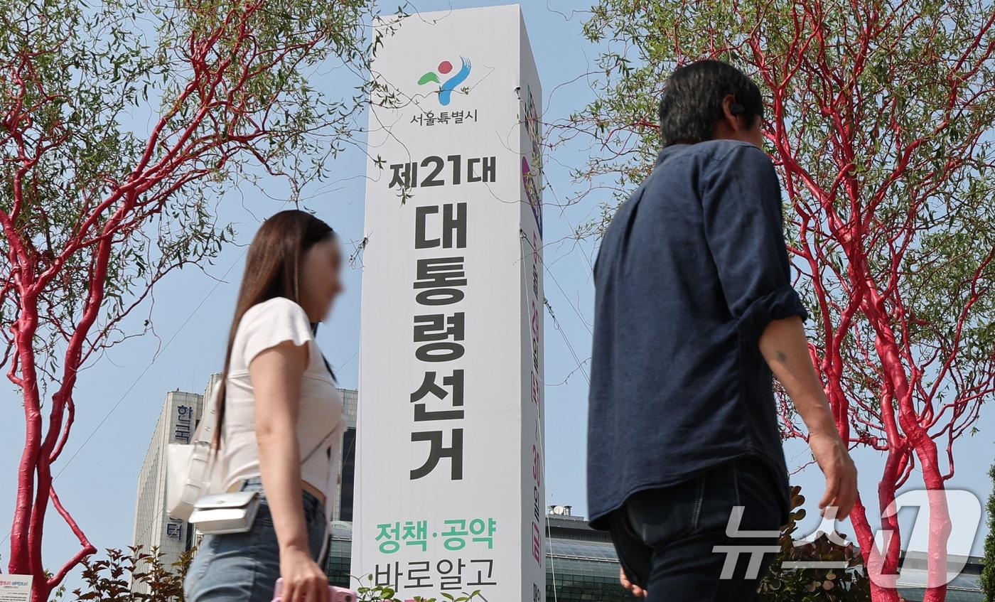 제21대 대통령선거를 이틀 앞둔 1일 서울 중구 서울광장에 세워진 대선 홍보 조형물 앞으로 시민들이 지나가고 있다. 2025.6.1/뉴스1 ⓒ News1 박지혜 기자