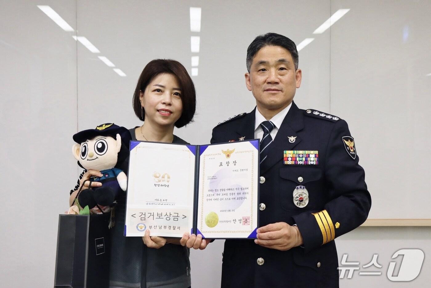 지난 5일 모바일 상품권을 무단으로 도용한 60대를 검거하는데 도움을 준 마트 직원(왼쪽)이 표창장을 받고 경찰 관계자와 기념사진을 찍고 있다.(부산 남부경찰서 제공. 재판매 및 DB 금지)