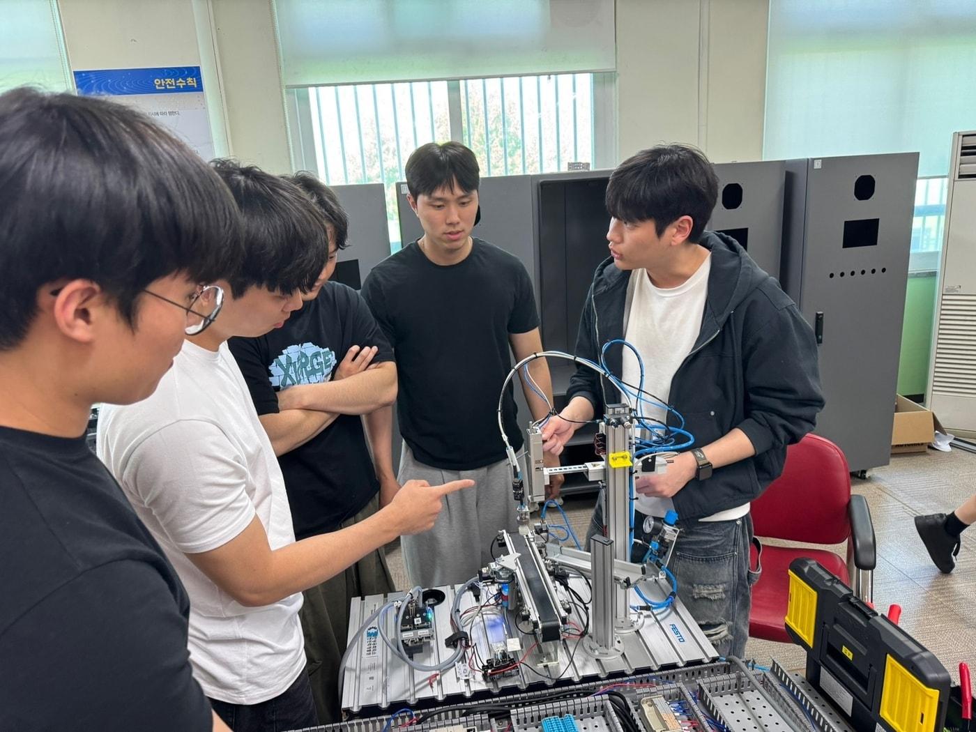 본문 이미지 - Dream Big Semicon Academy 1기 교육생들이 반도체 생산 공정을 구축하기 위한 장비 설비 실습 진행하고 있다. 사진= DB하이텍 제공