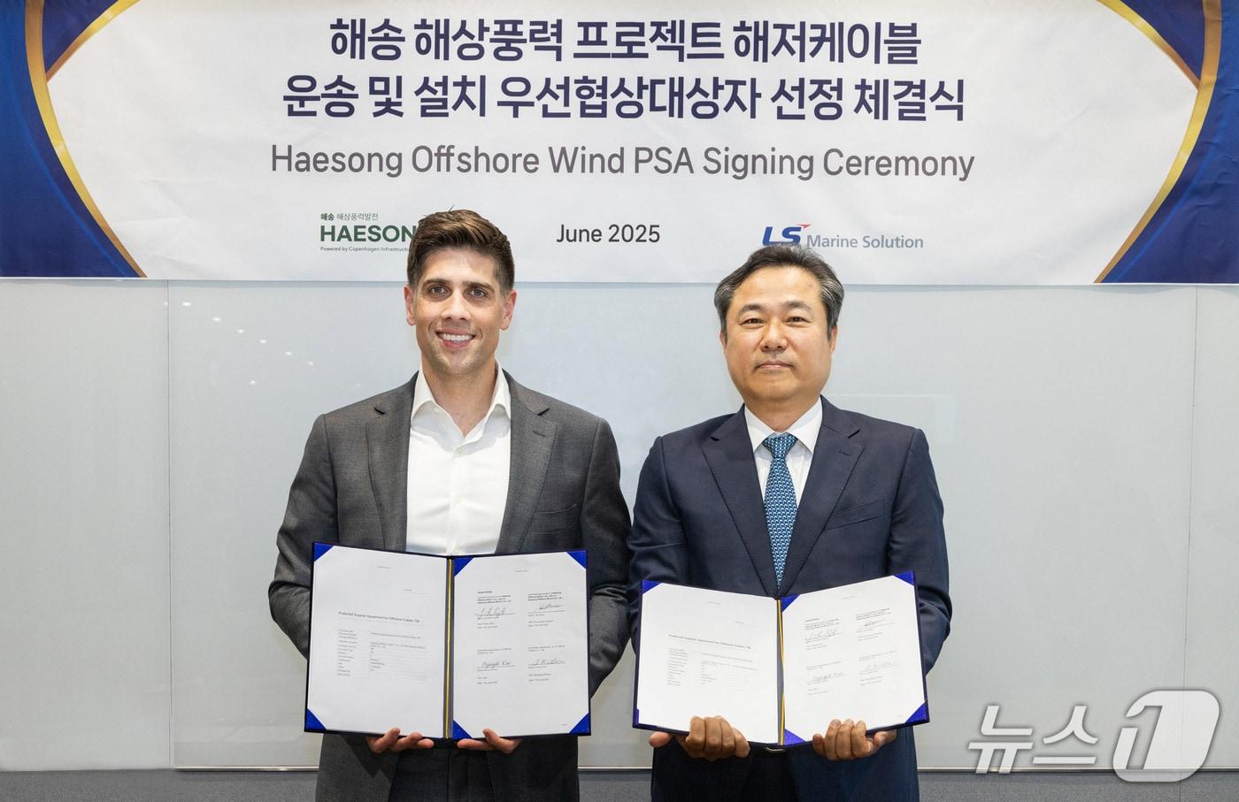 김병옥 LS마린솔루션 대표(오른쪽)와 조나단 스핑크 COP 코리아 대표가 11일 늦은 오후 종각 센트로폴리스에 위치한 ㈜해송해상풍력발전 서울 사무실에서 진행된 우선협상공급합의서(PSA) 체결식 후 기념촬영을 하고 있다.(LS전선 제공)
