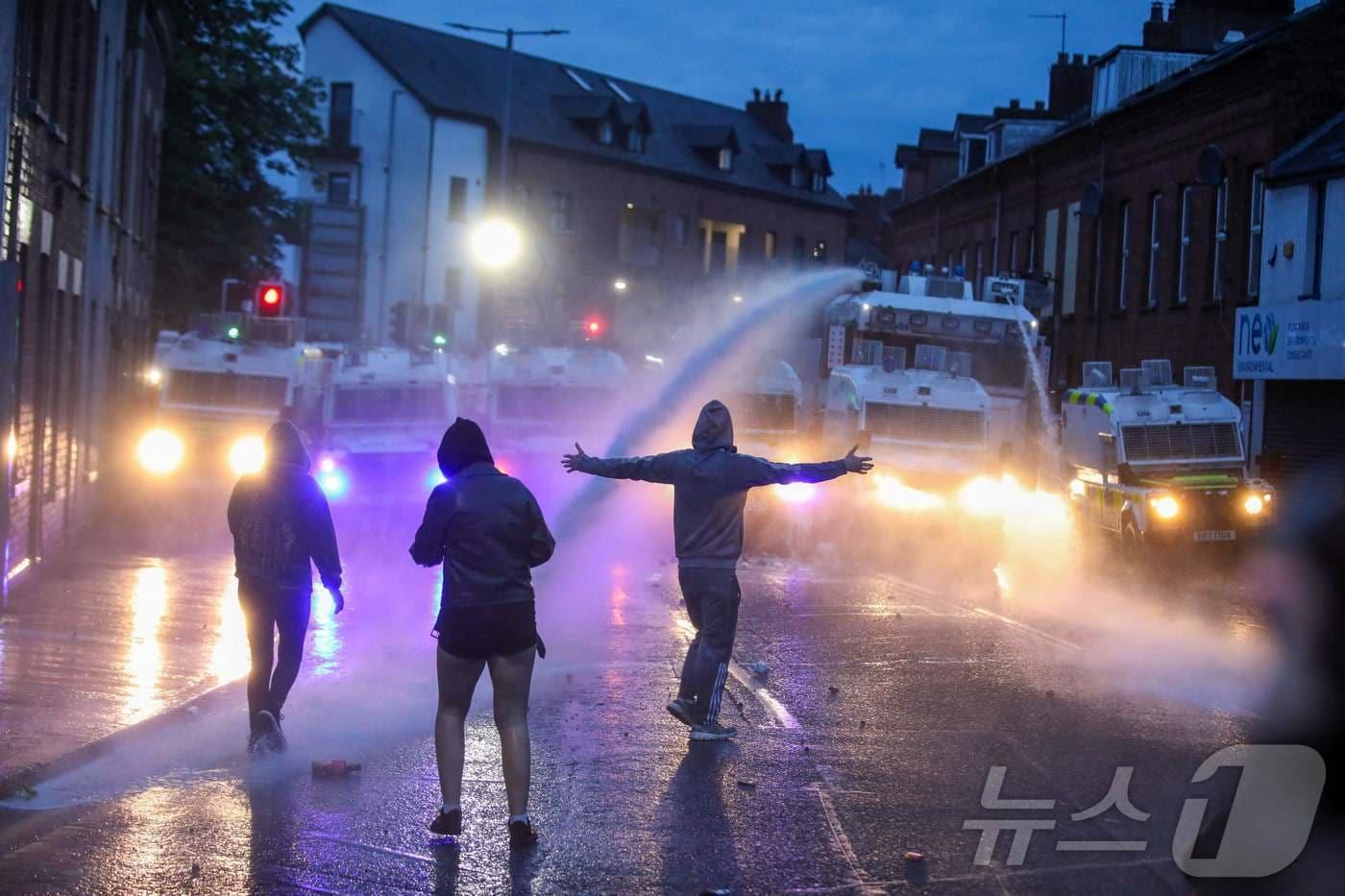 북아일랜드 밸리미나에서 반(反) 이민 시위에 모인 시위대를 해산시키기 위해 11일(현지시간) 경찰이 물대포를 발사하고 있다. 2025.6.11 ⓒ AFP=뉴스1 ⓒ News1 김경민 기자