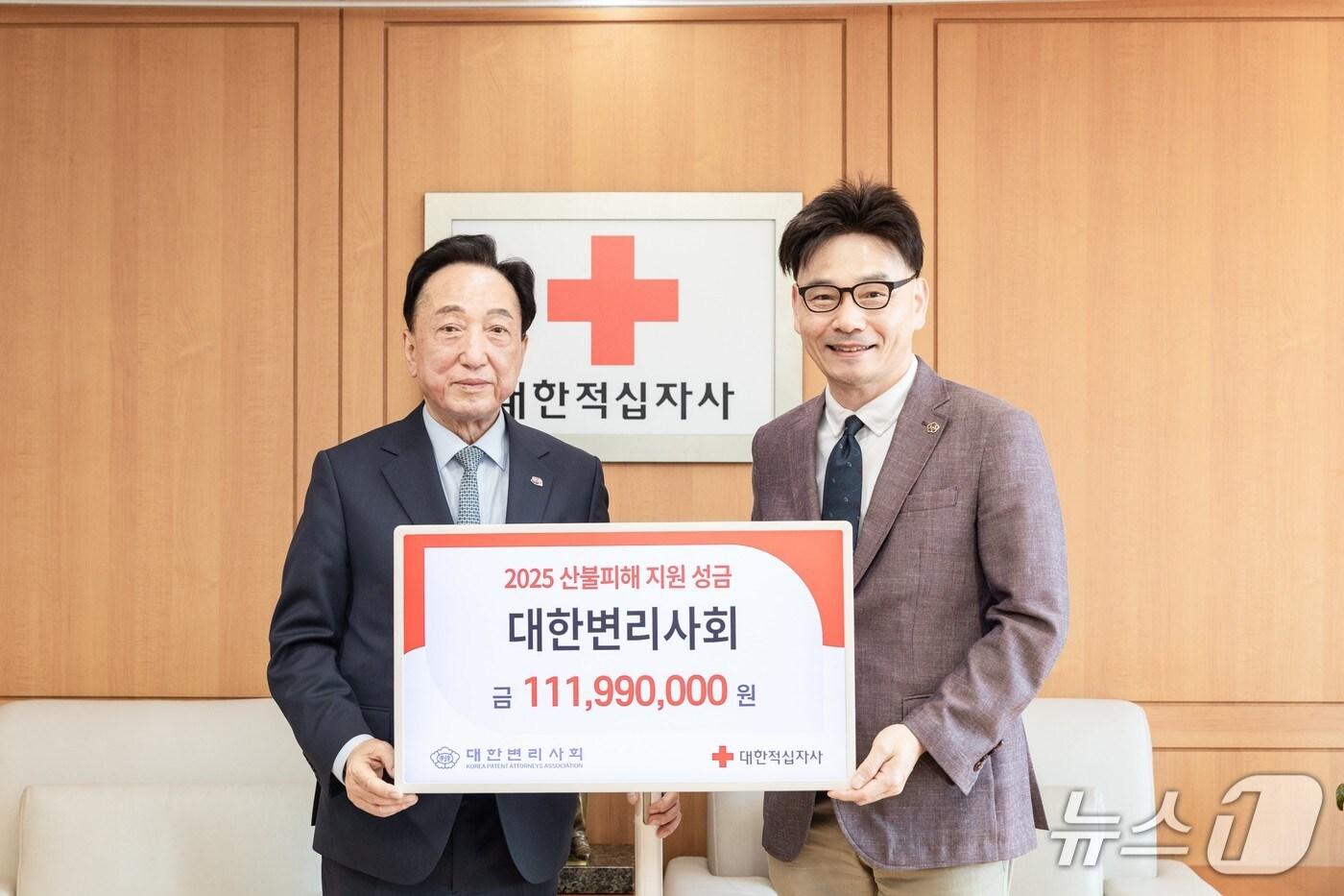 김두규 회장(오른쪽)이 김철수 대한적십자사 회장에게 성금을 전달하고 기념사진을 찍고 있다. (대한변리사회 제공.재판매 및 DB금지)/뉴스1 