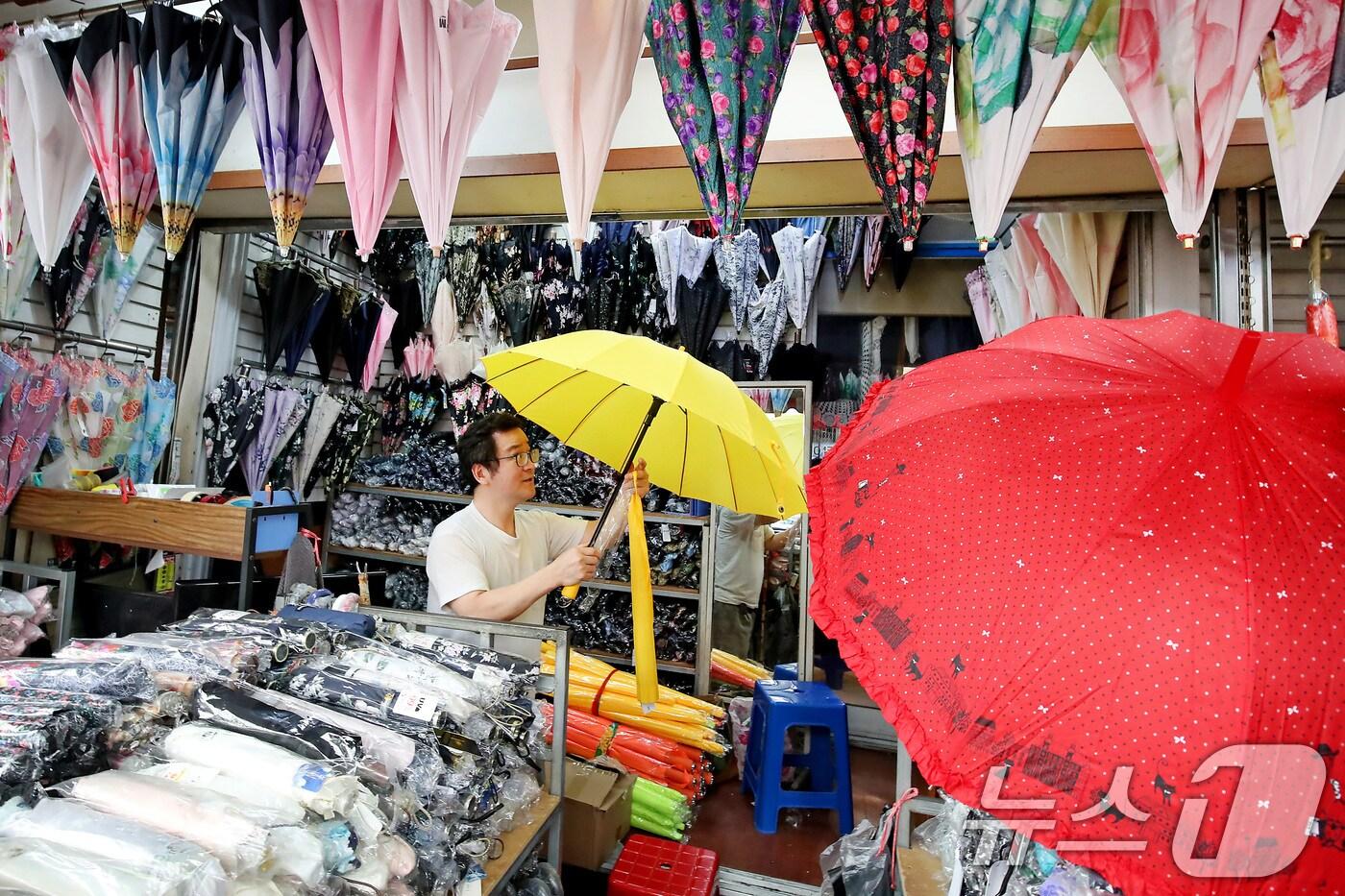 제주에서 올해 첫 장마가 시작된 12일 오후 대구 중구 서문시장 한 우산가게에서 주인이 봄철 양산에 밀렸던 우산을 꺼내 진열하고 있다. 평년보다 일주일 빠른 이번 장마는 13일 오후부터 대구·경북에도 비를 뿌릴 전망이다. 2025.6.12/뉴스1 ⓒ News1 공정식 기자