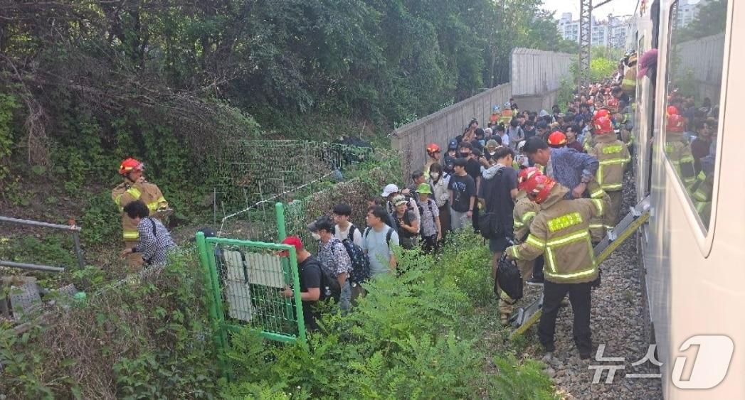 본문 이미지 -  12일 오후 3시 5분께 1호선 안양~구로 구간 상행2선을 달리던 전동열차가 전기적 문제로 멈춰서며 승객들이 도보로 인근 역까지 이동하는 모습(경기도소방재난본부 제공. 재판매 및 DB 금지)/뉴스1 
