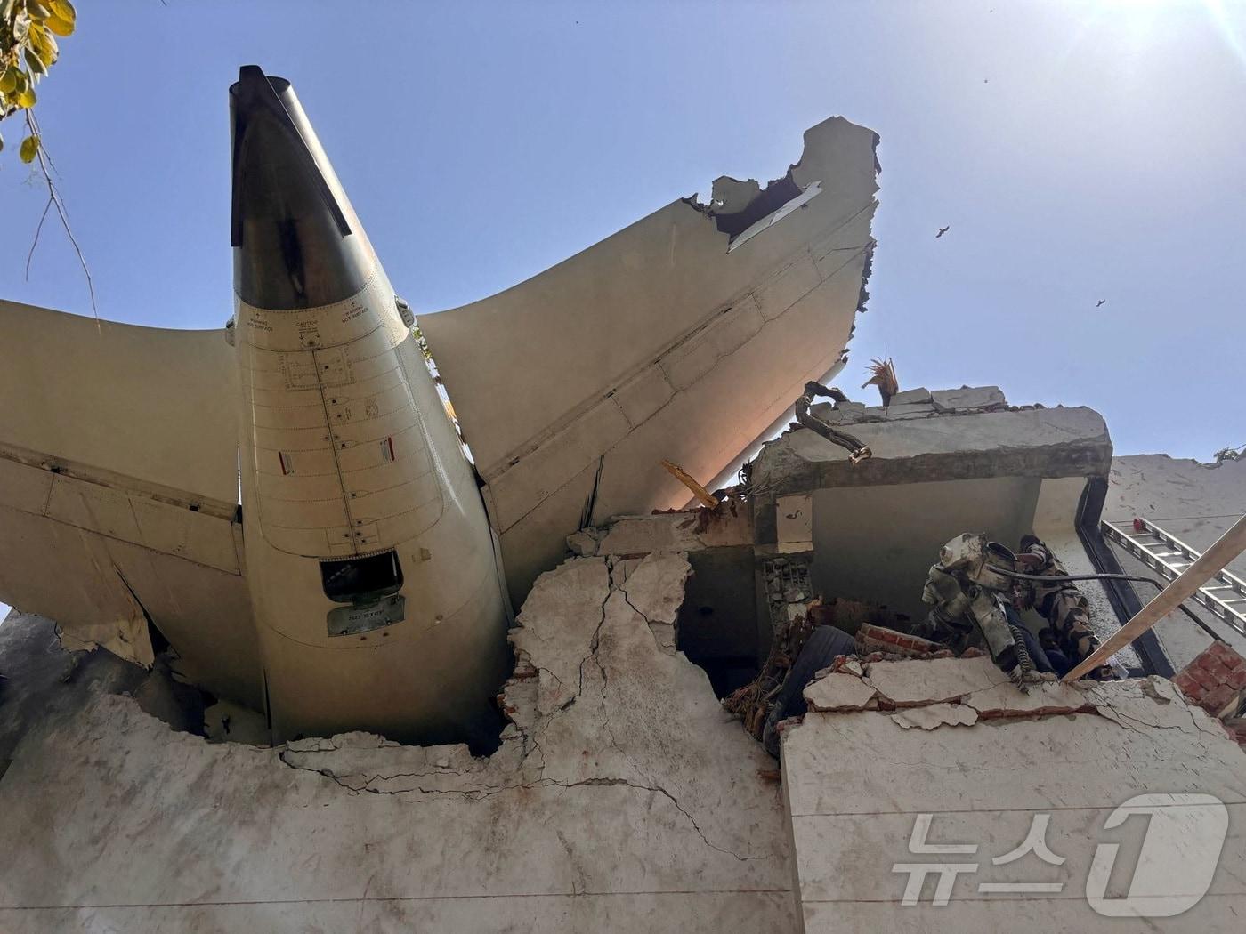 본문 이미지 - 인도 에어인디아 소속 보잉 787드림라이너 여객기가 6월 12일&#40;현지시간&#41; 인도 서부 아메다바드 공항 인근에서 추락했다. 사진은 추락한 건물 꼭대기에 기체 꼬리가 박힌 모습. 2025.06.12 ⓒ 로이터=뉴스1 ⓒ News1 최종일 선임기자