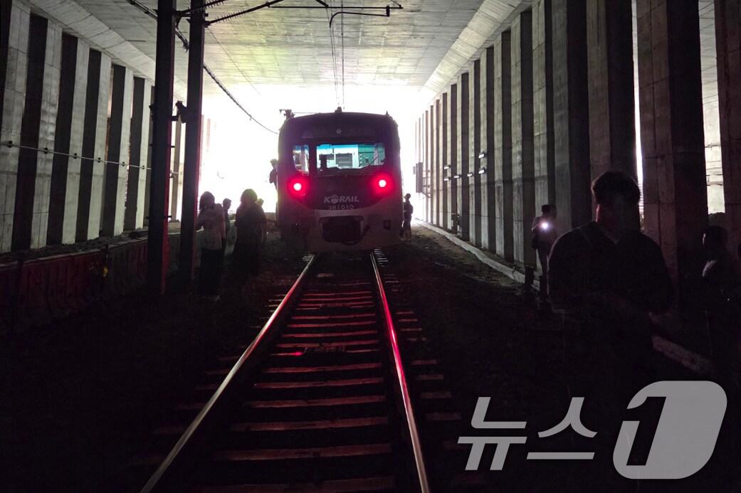본문 이미지 - 13일 오전 경의중앙선 신촌역 인근에서 사다리차 전도사고가 발생해 가좌역~신촌역 구간이 양방향 통제된 가운데 서울역행 경의중앙선 열차에 탑승한 승객들이 열차에서 내려 선로를 따라 대피하고 있다. &#40;독자 제공, 재판매 및 DB금지&#41;