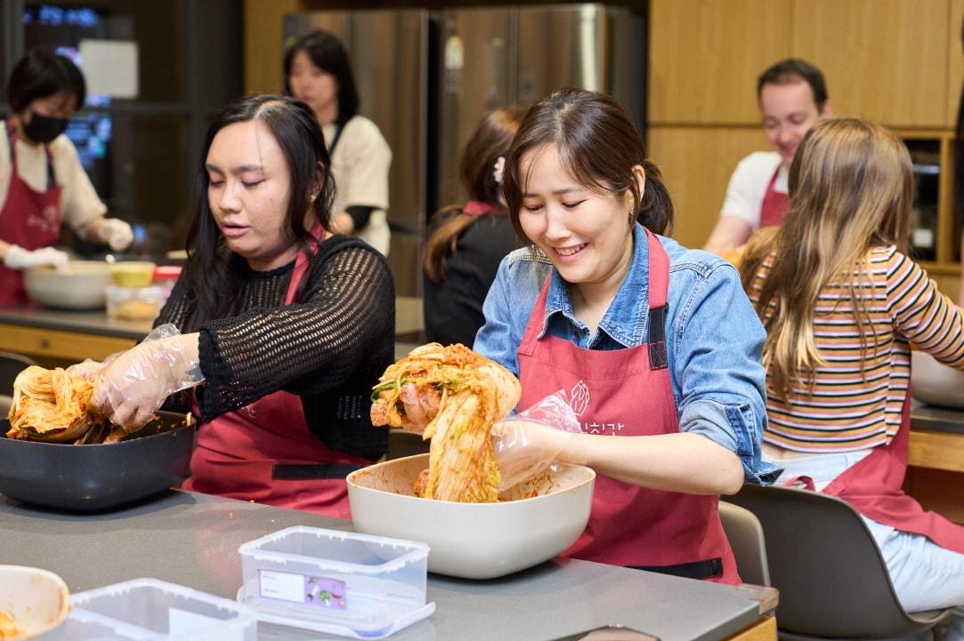 본문 이미지 -  풀무원 뮤지엄김치간에 방문한 외국인 관람객들이 김치 만들기 체험을 하고 있다.(풀무원 제공)