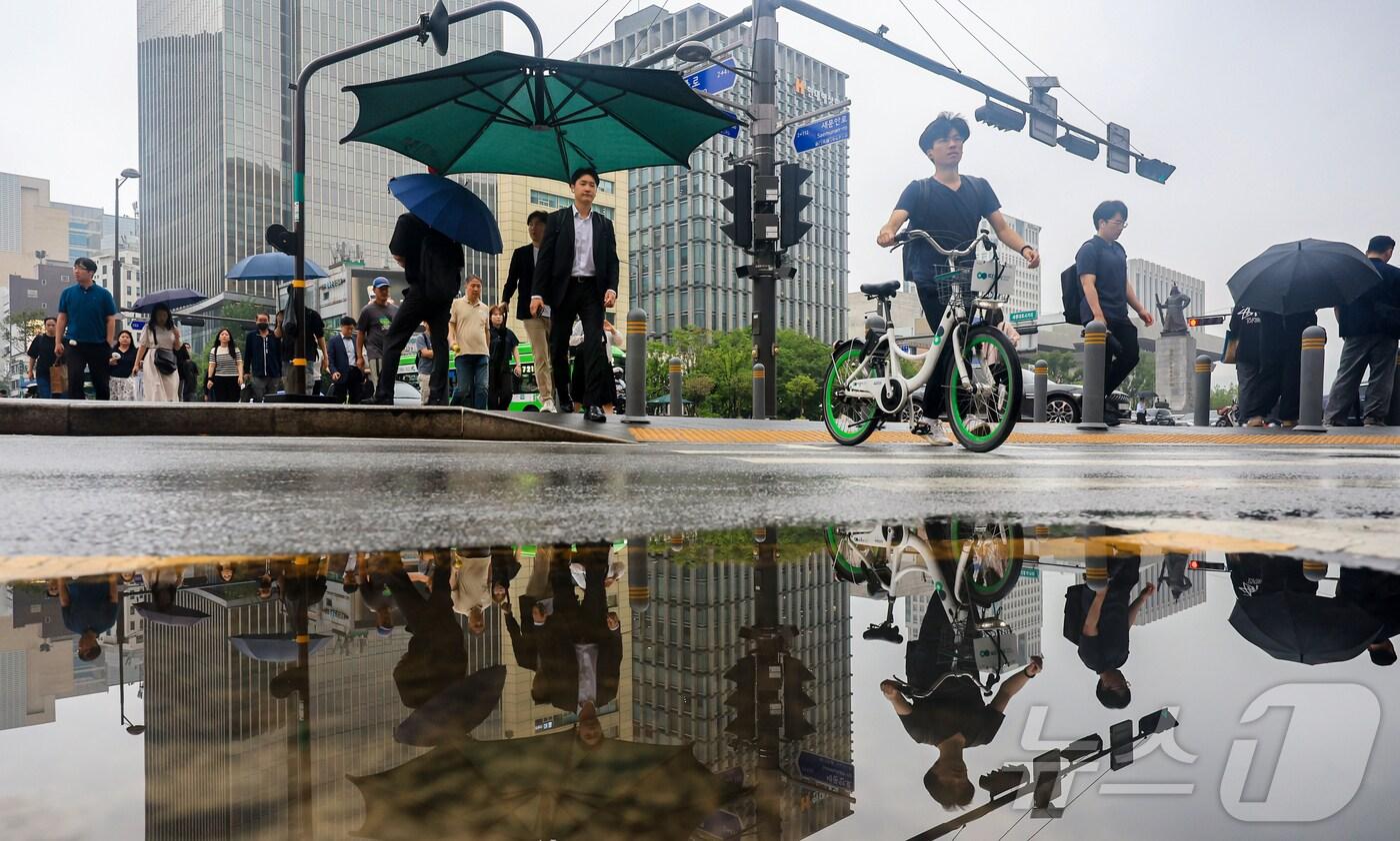 부슬비가 내리는 16일 오전 서울 종로구 광화문 네거리에서 시민들이 출근길을 서두르고 있다. 기상청은 이날 전국 대부분 지역에 비가 내리겠고, 내륙을 중심으로 낮 기온이 30도 안팎으로 오르는 등 덥고 습한 날씨가 예상된다고 밝혔다. 2025.6.16/뉴스1 ⓒ News1 김진환 기자