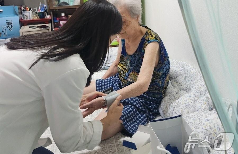 본문 이미지 - 보건 전문가가 지역주민 혈압을 측정 중인 모습. (한국마사회 제공)