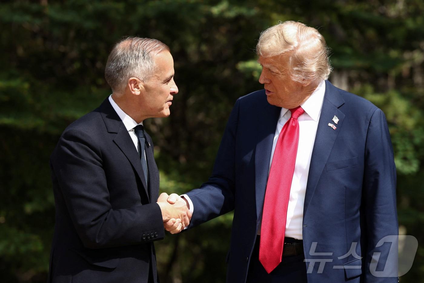 도널드 트럼프 미국 대통령과 마크 카니 캐나다 총리가 16일&#40;현지시간&#41; 캐나다 앨버타주 캐내내스키스에서 열린 주요 7개국&#40;G7&#41; 정상회의 공식 환영 행사에서 악수하고 있다. 2025.06.16 ⓒ 로이터=뉴스1 ⓒ News1 류정민 특파원