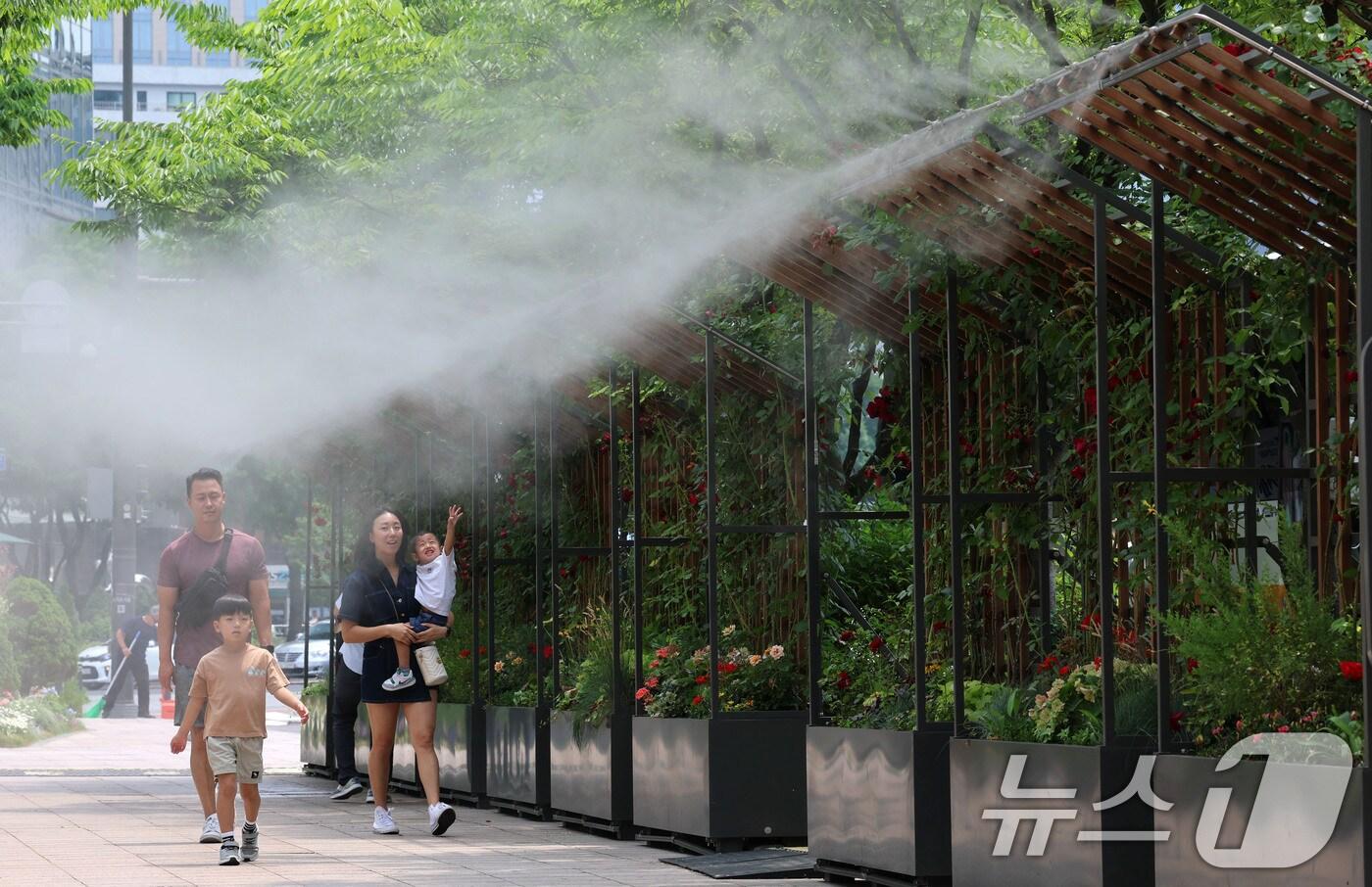 서울 최고기온이 29도까지 오르는 등 초여름 날씨를 보인 17일 서울시청 앞 서울광장을 찾은 한 가족이 쿨링포그 앞을 지나며 더위를 식히고 있다.  2025.6.17/뉴스1 ⓒ News1 박세연 기자