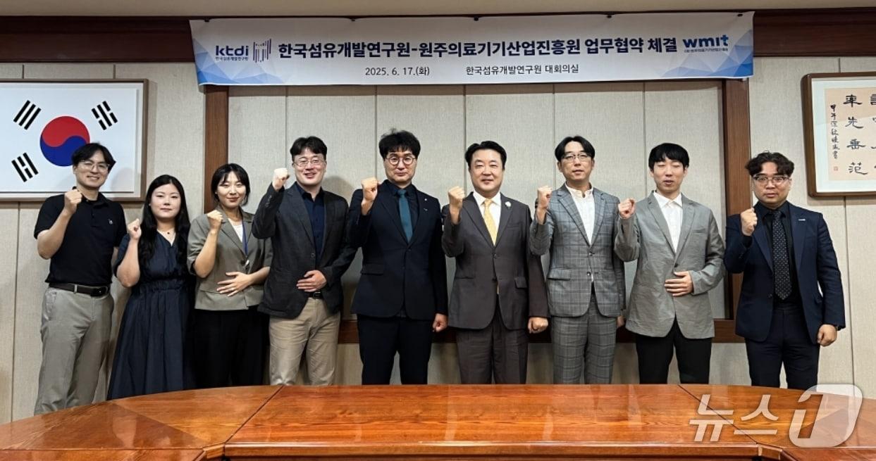 본문 이미지 - 한국섬유개발연구원과 원주의료기기산업진흥원 직원들이 의료용 융합소재 공동 연구와 기술 발전 촉진을 위한 업무협약을 체결한 뒤 파이팅을 외치고 있다.(섬유개발연구원 제공. 재판매 및 DB 금지)