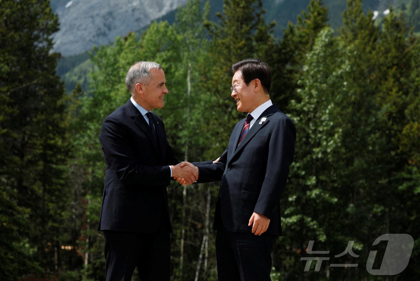 이재명 대통령이 17일(현지시간) 캐나다 앨버타주 카나나스키스 주요 7개국(G7) 정상회의장에서 열린 초청국 공식 환영식에 도착해 의장국 마크 카니 캐나다 총리와 악수하고 있다. ⓒ 로이터=뉴스1 ⓒ News1 김진환 기자