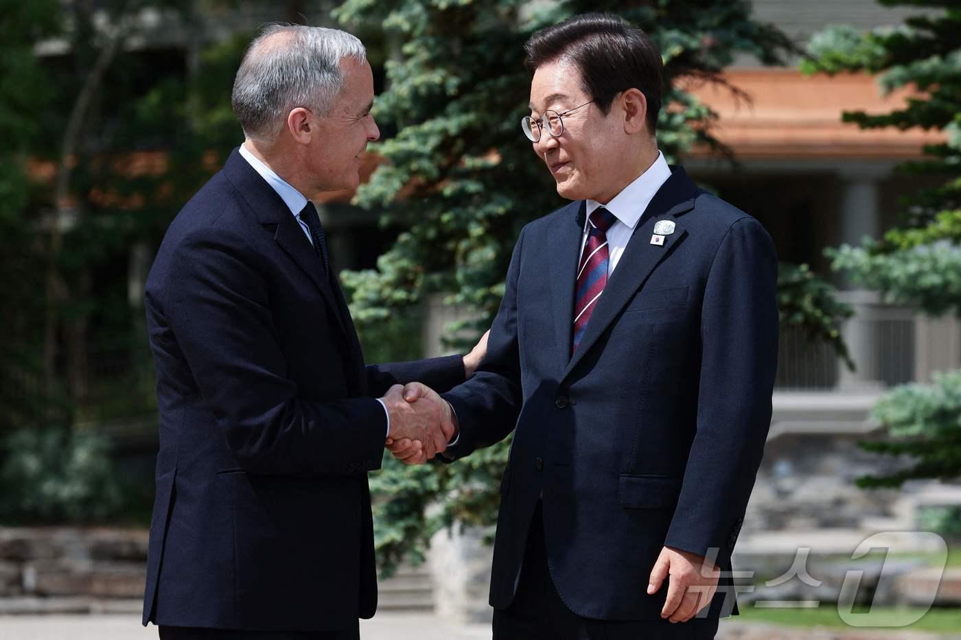 이재명 대통령이 17일(현지 시간) 캐나다 앨버타주 카나나스키스 주요 7개국(G7) 정상회의장에서 열린 초청국 공식 환영식에 도착해 의장국 마크 카니 캐나다 총리와 악수하고 있다. ⓒ AFP=뉴스1 ⓒ News1 송원영 기자