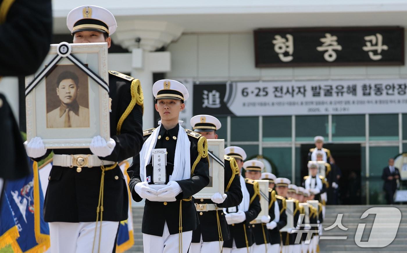 6·25전쟁 75주년을 일주일 앞둔 18일 서울 동작구 국립서울현충원에서 열린 6·25전쟁 전사자 발굴 유해 합동 안장식에서 호국영웅 7위의 영정과 영현이 안장식 장소로 봉송되고 있다. 2025.6.18/뉴스1 ⓒ News1 오대일 기자