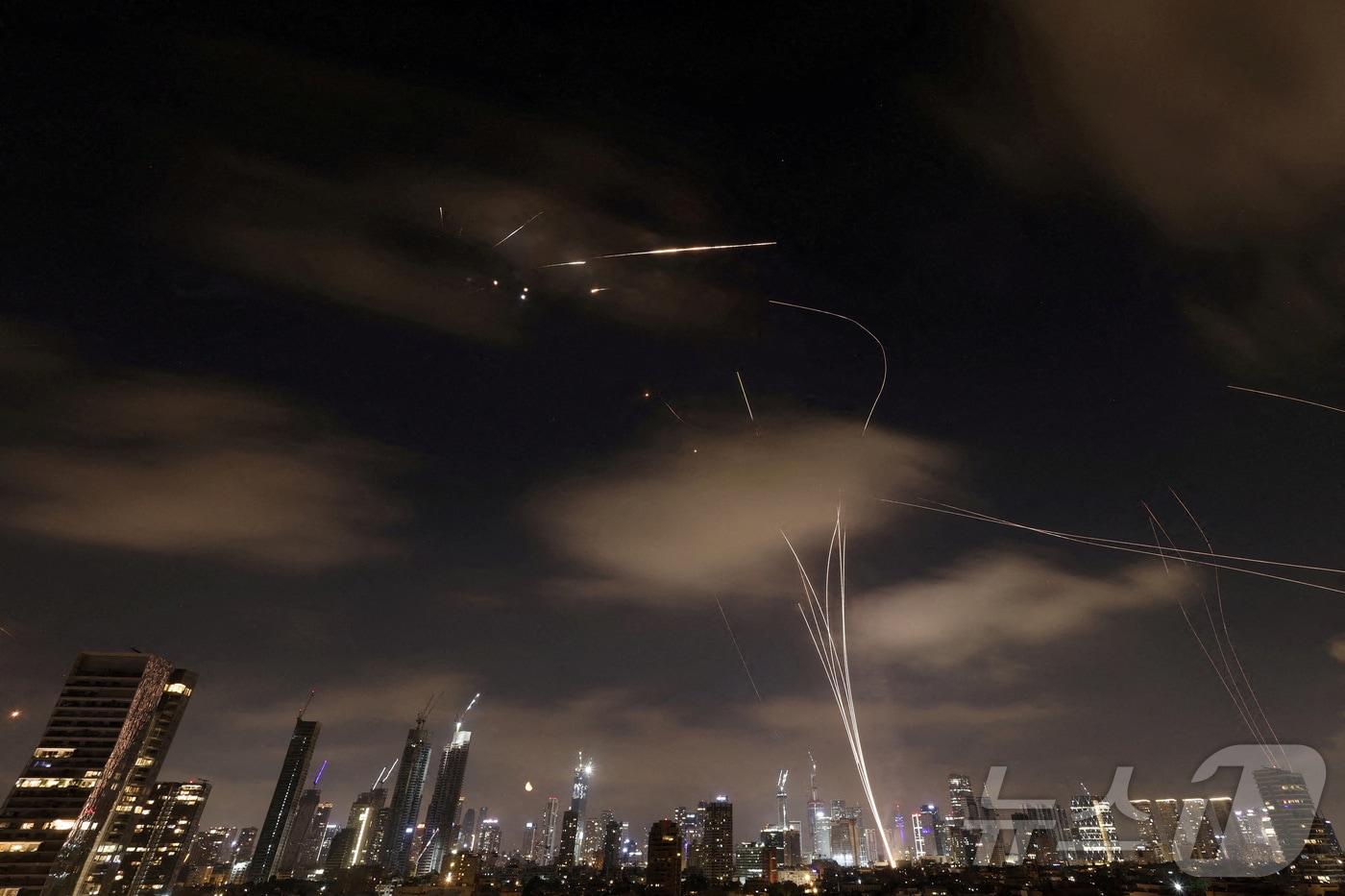 본문 이미지 - 작년 6월 18일(현지시간) 이란에서 발사된 미사일이 이스라엘에서 요격되고 있다. 사진은 텔아비브에서 촬영된 것이다. 2025.06.18 ⓒ 로이터=뉴스1 ⓒ News1 최종일 선임기자