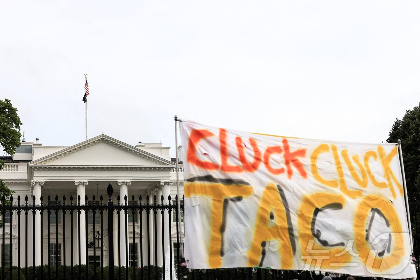 본문 이미지 - 17일(현지시간) 미국 워싱턴 DC 백악관 앞에 '꼬끼오 꼬끼오 타코'(CLUCK CLUCK TACO) 라고 적힌 현수막이 보인다. 도널드 트럼프 미국 대통령은 이스라엘-이란 분쟁이 지속되는 가운데 주요 7개국(G7) 정상회의 중간에 조기 귀국했다. 타코는 '트럼프는 항상 닭처럼 겁먹고 물러선다'(Trump Always Chickens Out)의 약자로, 뉴욕 증시 트레이더들이 트럼프 대통령의 변덕스러운 관세 정책을 비꼬는 신조어다. 2025.6.17ⓒ 로이터=뉴스1