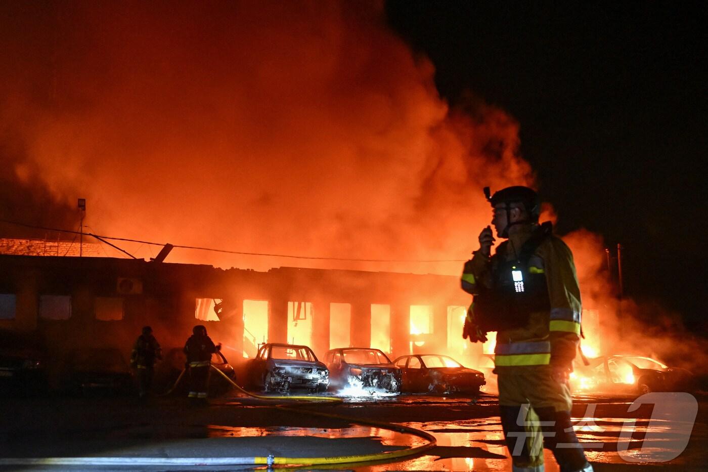 18일&#40;현지시간&#41; 우크라이나 자포리자에서 러시아의 드론 공격을 받아 불타고 있는 한 기업 건물 근처에서 소방관들이 진화 작업을 벌이고 있다. 2025.06.18 ⓒ 로이터=뉴스1 ⓒ News1 김지완 기자