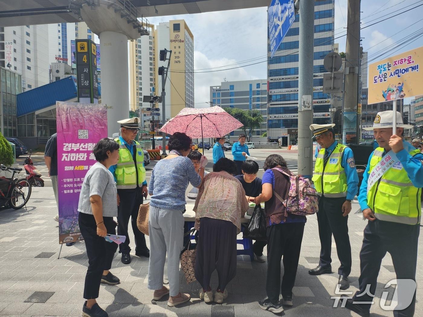 본문 이미지 - 부산도시철도 2호선 사상역 앞에서 구민들이 철도 경부선 구포~가야 구간 지하화를 위한 서명운동에 참여하고 있다.(사상구 제공. 재판매 및 DB 금지)
