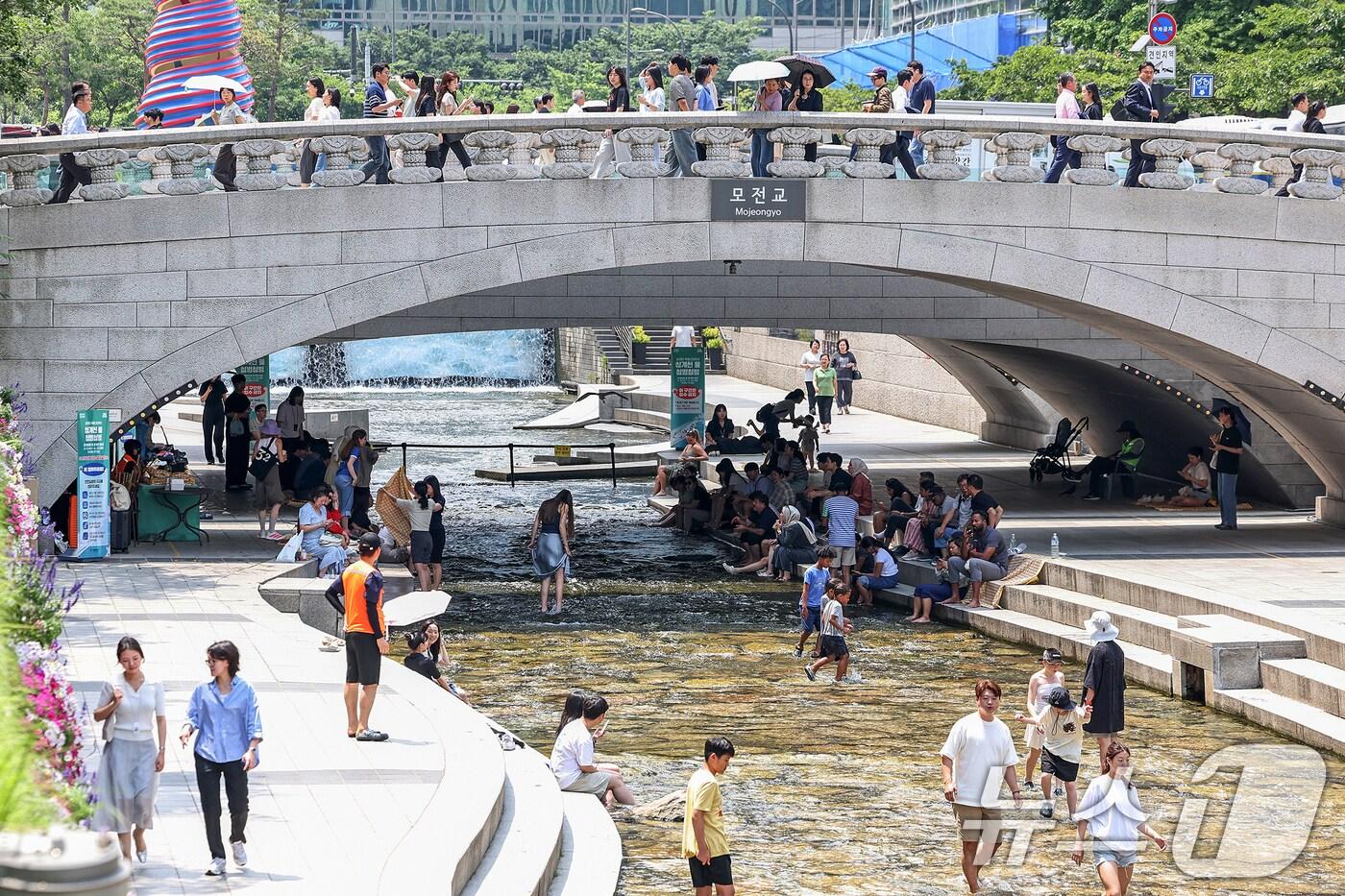 서울 지역 낮 최고 기온이 32도까지 올라 무더위가 찾아온 19일 서울중구 청계천에서 시민들과 외국인 관광객들이 모전교 그늘 아래에서 더위를 식히고 있다. 2025.6.19/뉴스1 ⓒ News1 민경석 기자