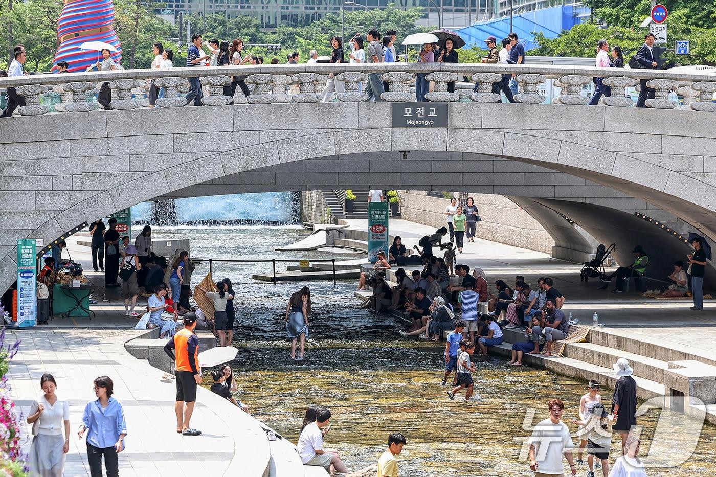 서울 지역 낮 최고 기온이 32도까지 올라 무더위가 찾아온 19일 서울중구 청계천에서 시민들과 외국인 관광객들이 모전교 그늘 아래에서 더위를 식히고 있다. 2025.6.19/뉴스1 ⓒ News1 민경석 기자