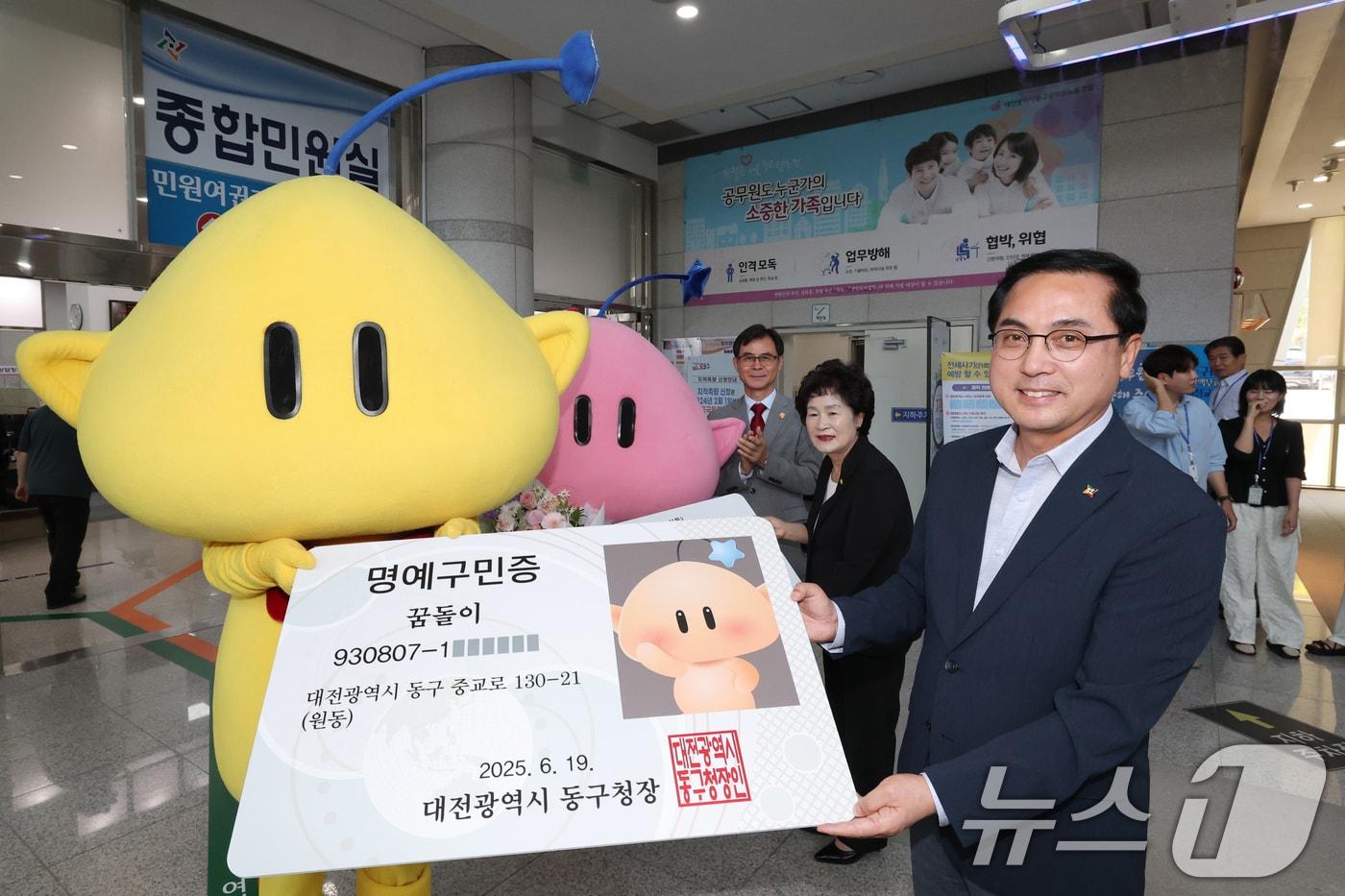박희조 대전 동구청장이 19일 동구청에서 전입신고를 마친 대전시 대표 캐릭터인 꿈돌이·꿈순이에게 ‘명예구민증’을 전달하고 있다.  2025.6.19/뉴스1 ⓒ News1 김기태 기자