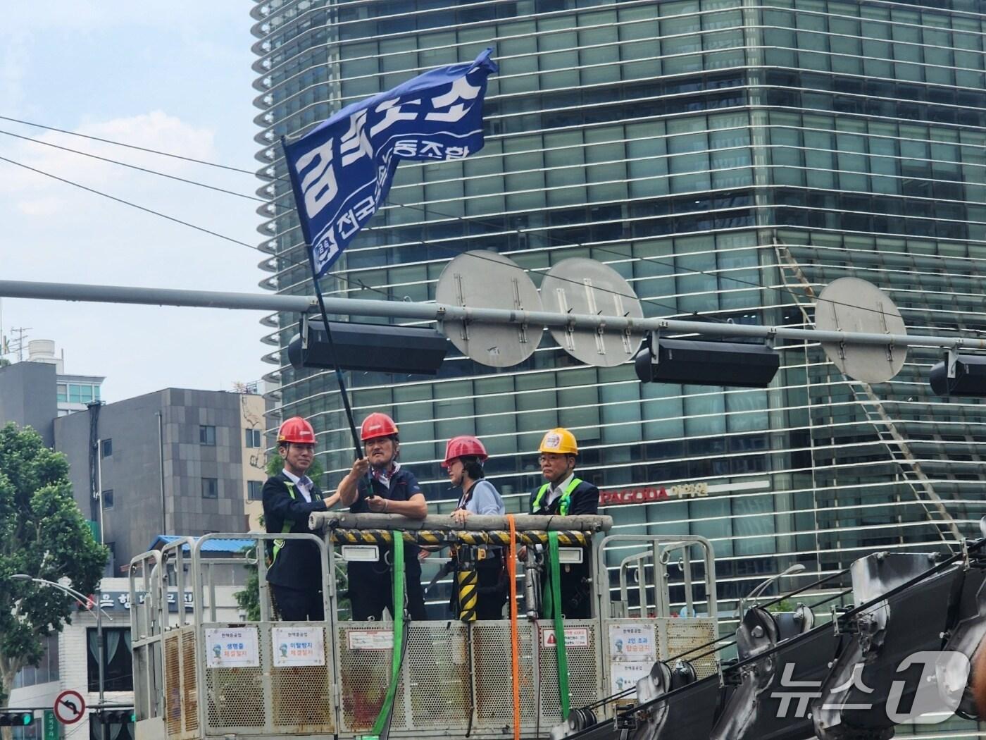 본문 이미지 - 서울 중구 한화 본사 앞 30m 높이 폐쇄회로&#40;CCTV&#41; 철탑에서 고공농성을 하던 김형수 지회장이 19일 오후 2시 30분쯤 크레인을 타고 지상으로 내려오는 모습.2025.6.19/뉴스1 ⓒ News1 권진영 기자