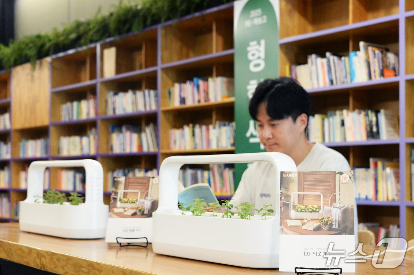 LG 틔운 미니를 활용해 조성된 내부 서가와 열람실 공간에서 독서하며 다양한 식물을 감상하는 모습&#40;LG전자 제공&#41;. ⓒ 뉴스1