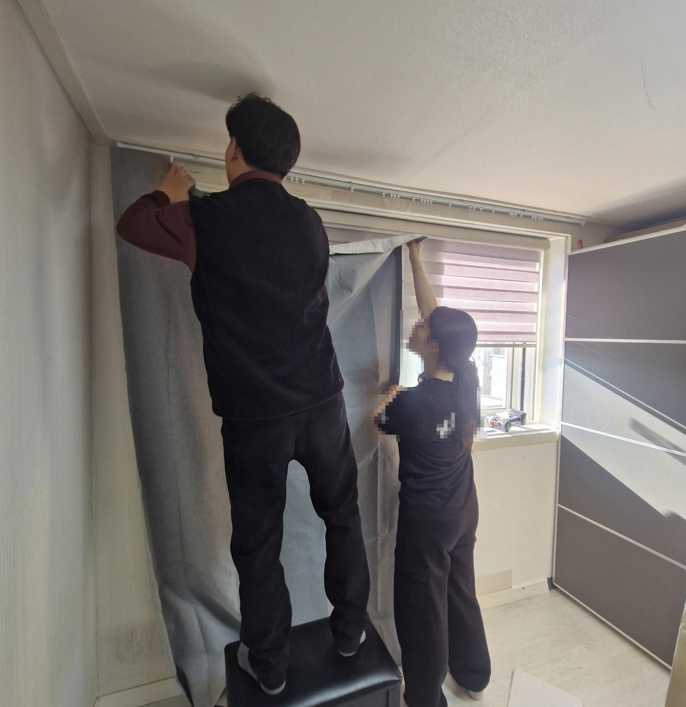 본문 이미지 - 보호관찰 대상자 자녀의 학업 환경을 위해 커튼을 달아주고 있다.(도봉구 제공)