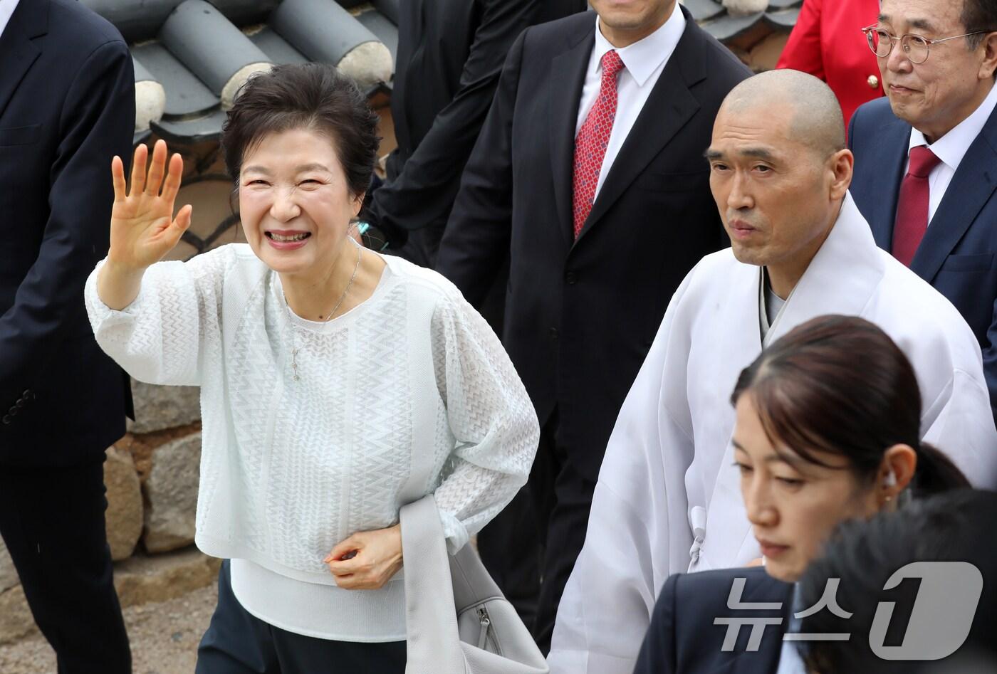 박근혜 전 대통령이 2일 부산 금정구 범어사를 방문해 주지 정오스님과 대웅전으로 향하며 지지자들에게 인사하고 있다. 2025.6.2/뉴스1 ⓒ News1 윤일지 기자