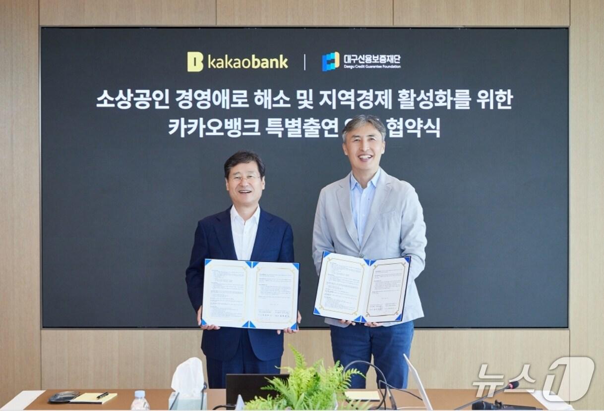 본문 이미지 - 박진우 대구신용보증재단 이사장&#40;왼쪽&#41;과 김석 카카오뱅크 뱅킹그룹장이 중소기업·소상공인 금융지원을 위한 특별출연 업무협약을 체결한 뒤 협약서를 펼쳐 보이고 있다.&#40;대구신보 제공. 재판매 및 DB 금지&#41;