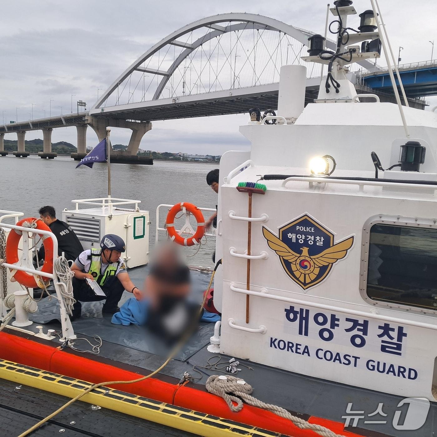 본문 이미지 - 군산해경이 구조된 A 씨를 인근 항포구에 대기 중인 119구급대에 인계하고 있다.&#40;군산해경 제공. 재판매 및 DB금지&#41;