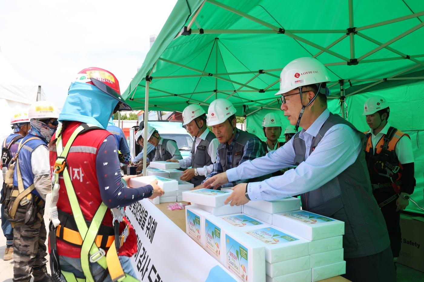박현철 롯데건설 부회장(앞줄 오른쪽)이 19일 대구 타임빌라스 수성 현장에서 근로자들에게 아이스크림 츄러스와 이온음료, 혹서기 용품 등을 나눠주고 있다./롯데건설 제공